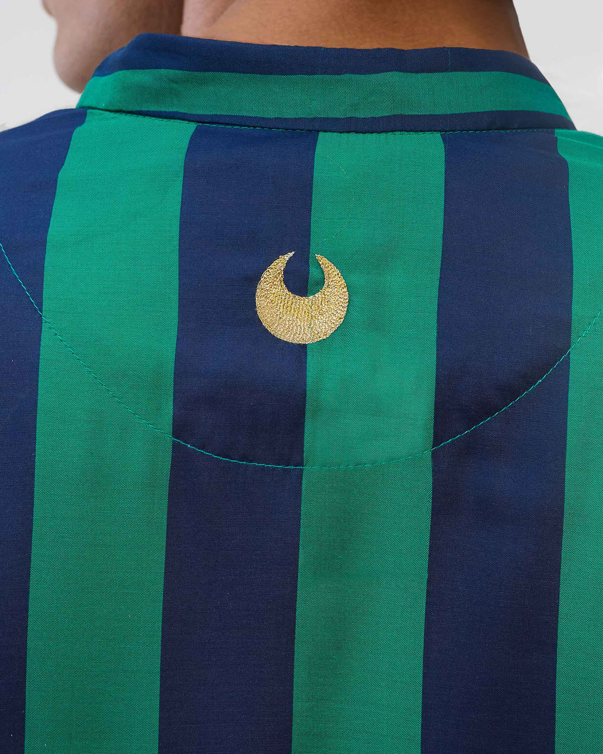Close-up of the gold motif on the back of a green and navy striped Gala Kurta.
