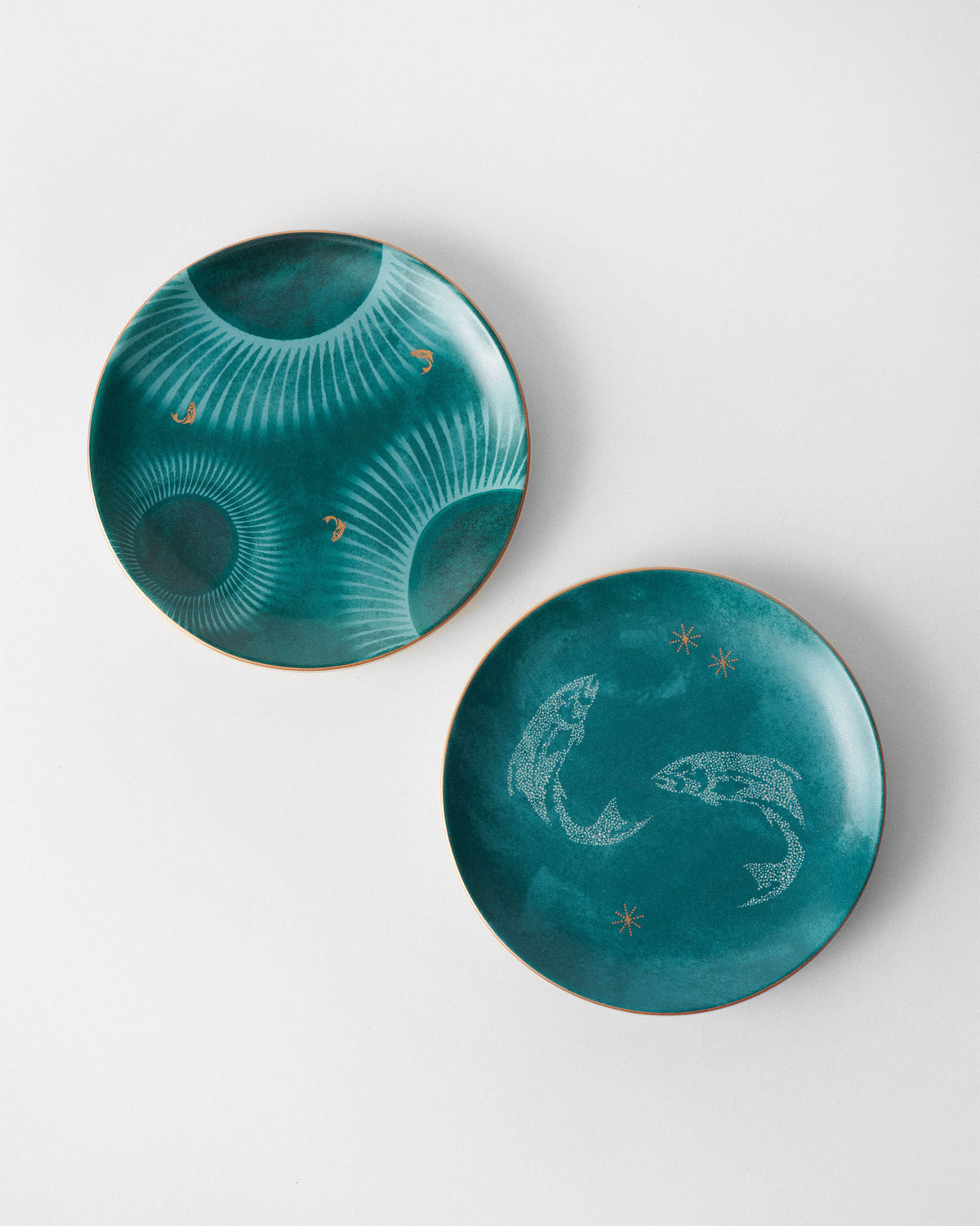 Two teal Caden quarter plates with sunburst and leaping fish prints.