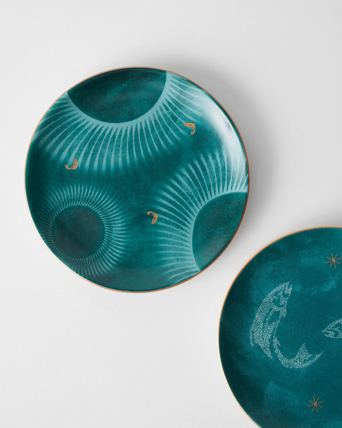 Teal Caden quarter plate with radial sunbursts and tiny gold fish.