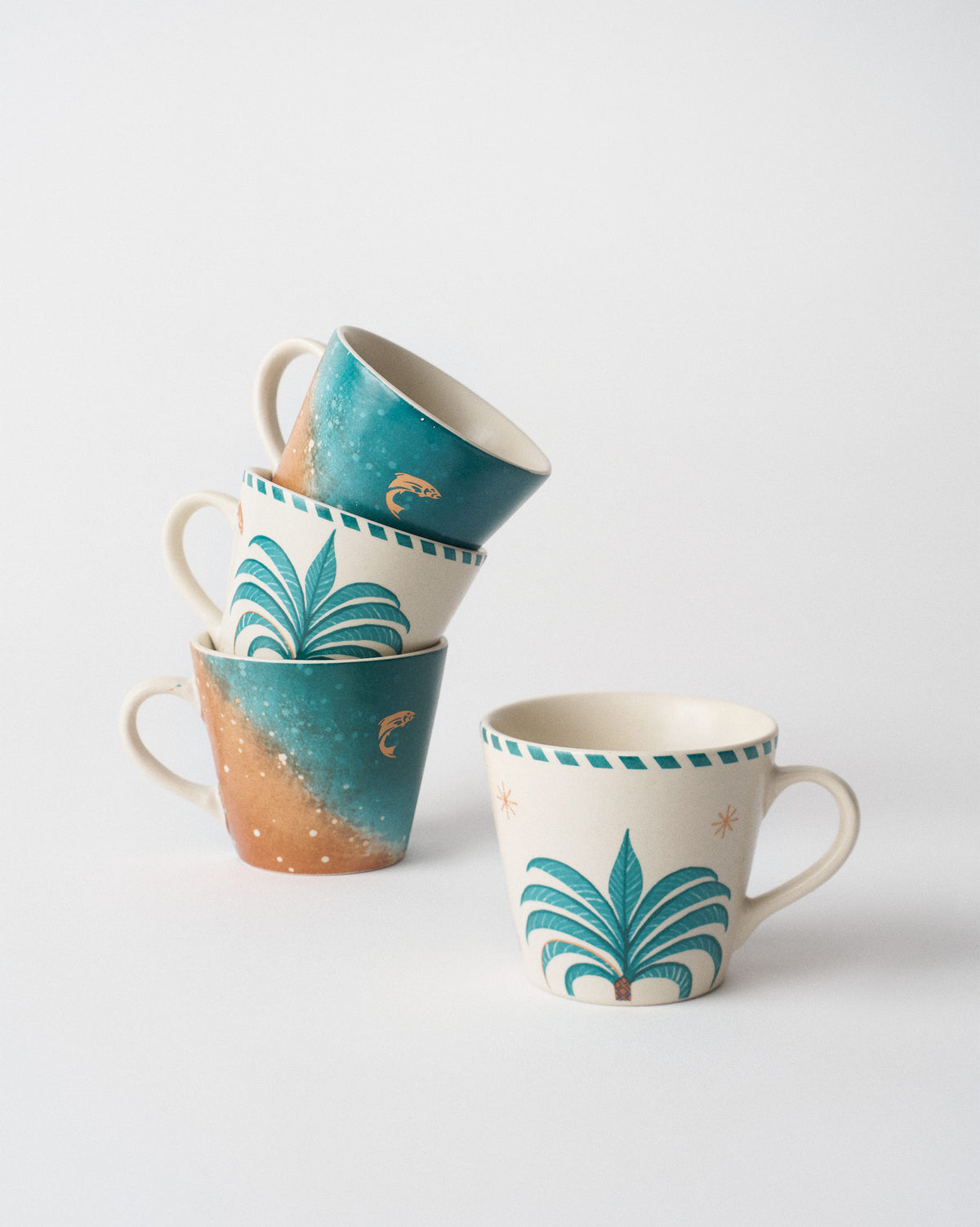 Aluna Espresso Mugs stacked to show palm-tree and seascape prints.