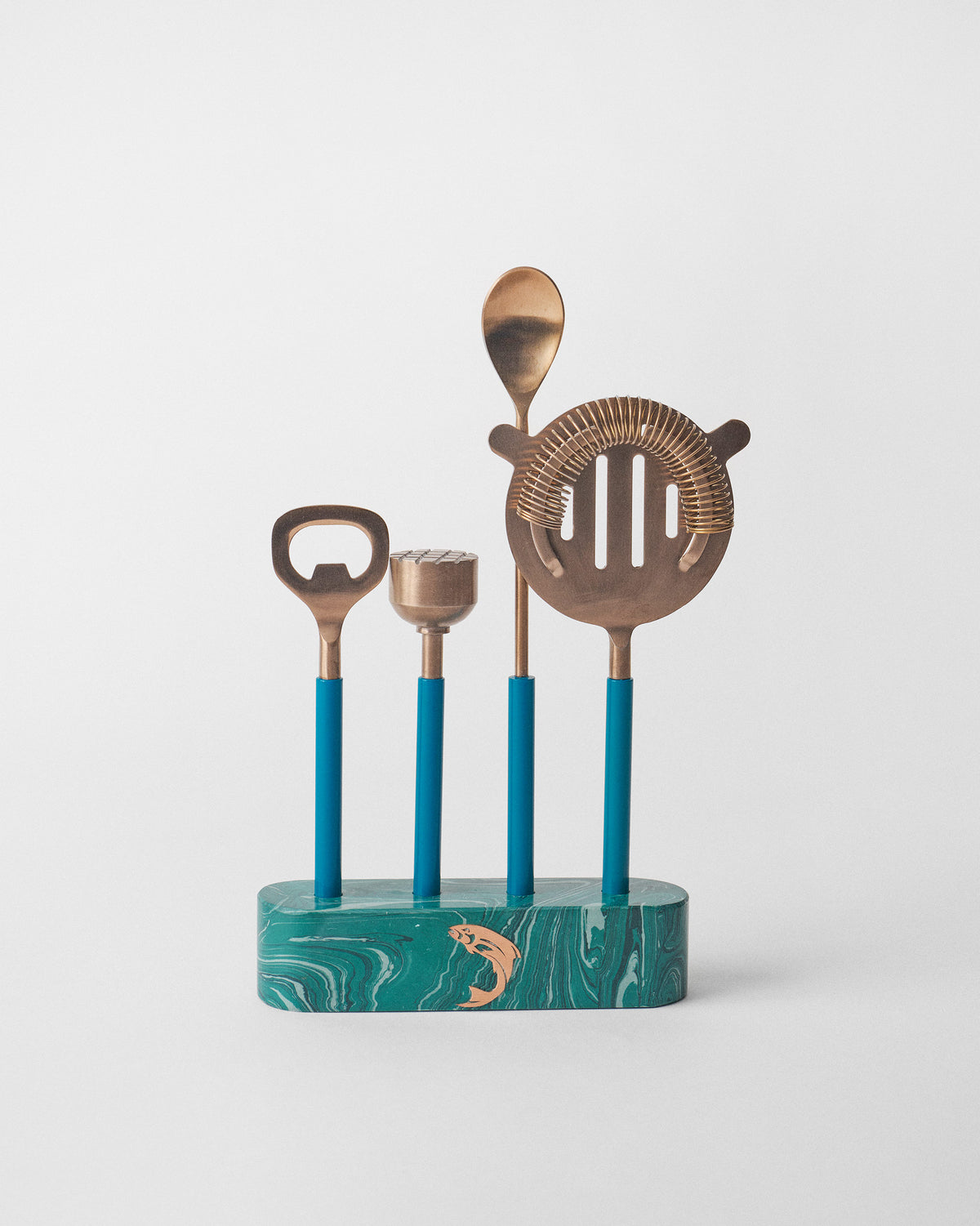 Cascade bar tools with teal handles in a green marbled base with a copper fish.