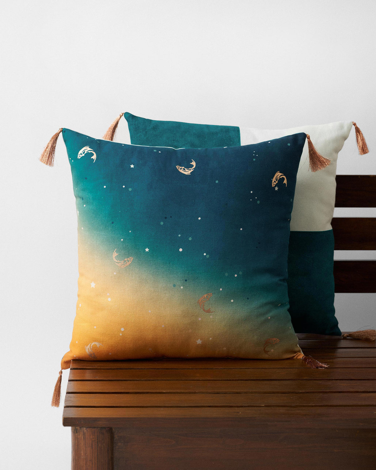 Lumen Cushion Cover with gold motifs on a teal and amber gradient.