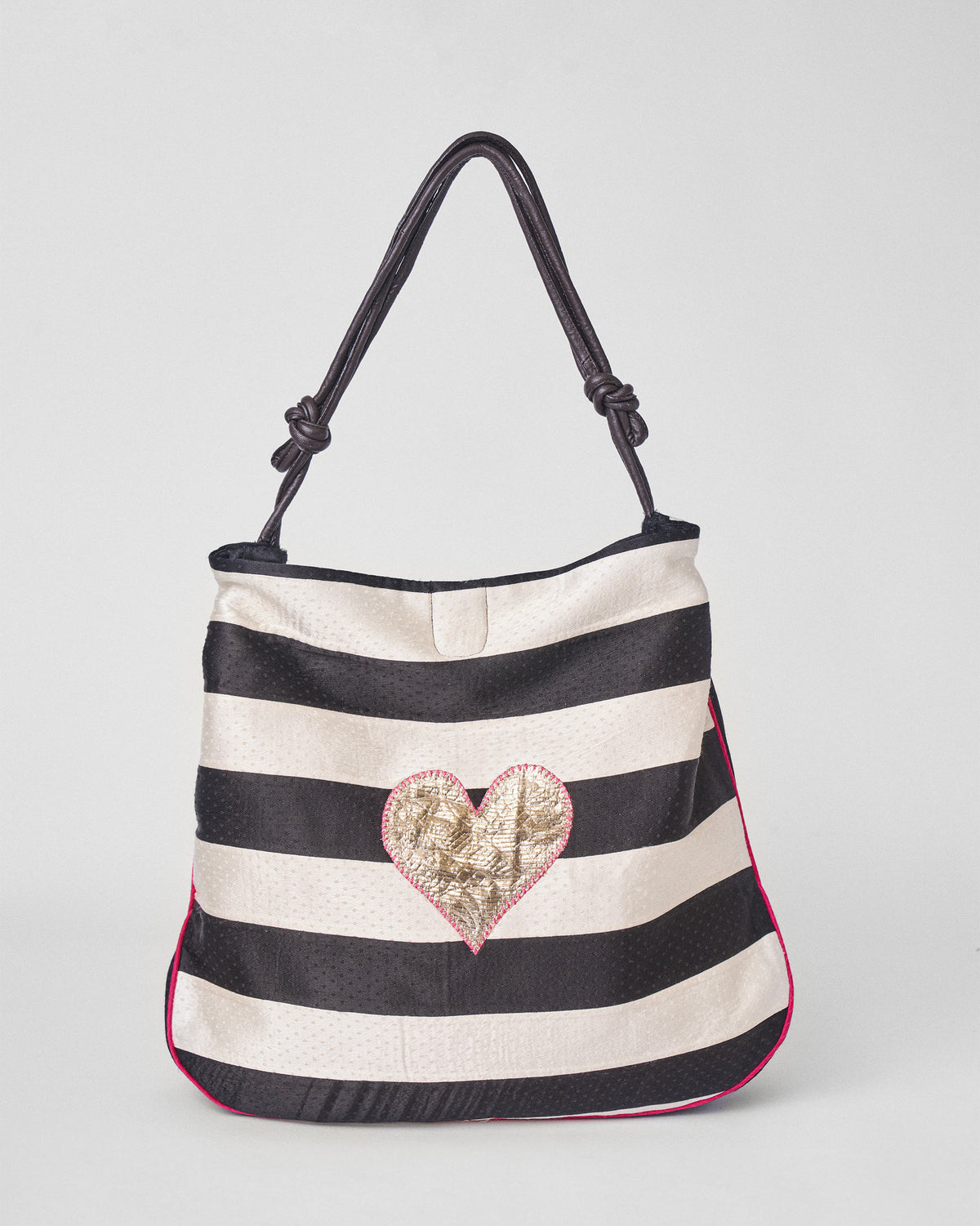 Black and ivory Nomad Tote with a gold heart.