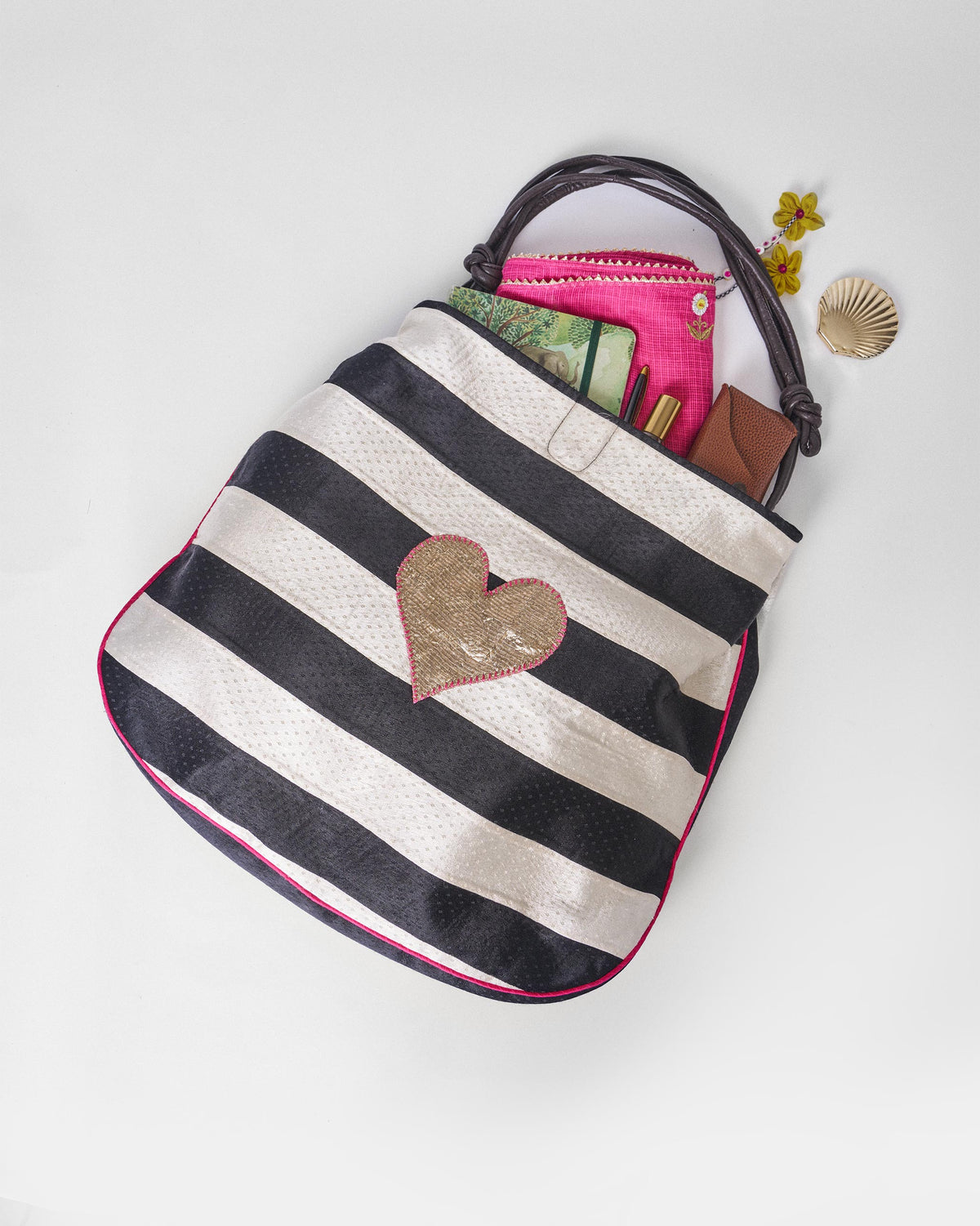 Black and ivory Nomad Tote open with a gold heart on the front.