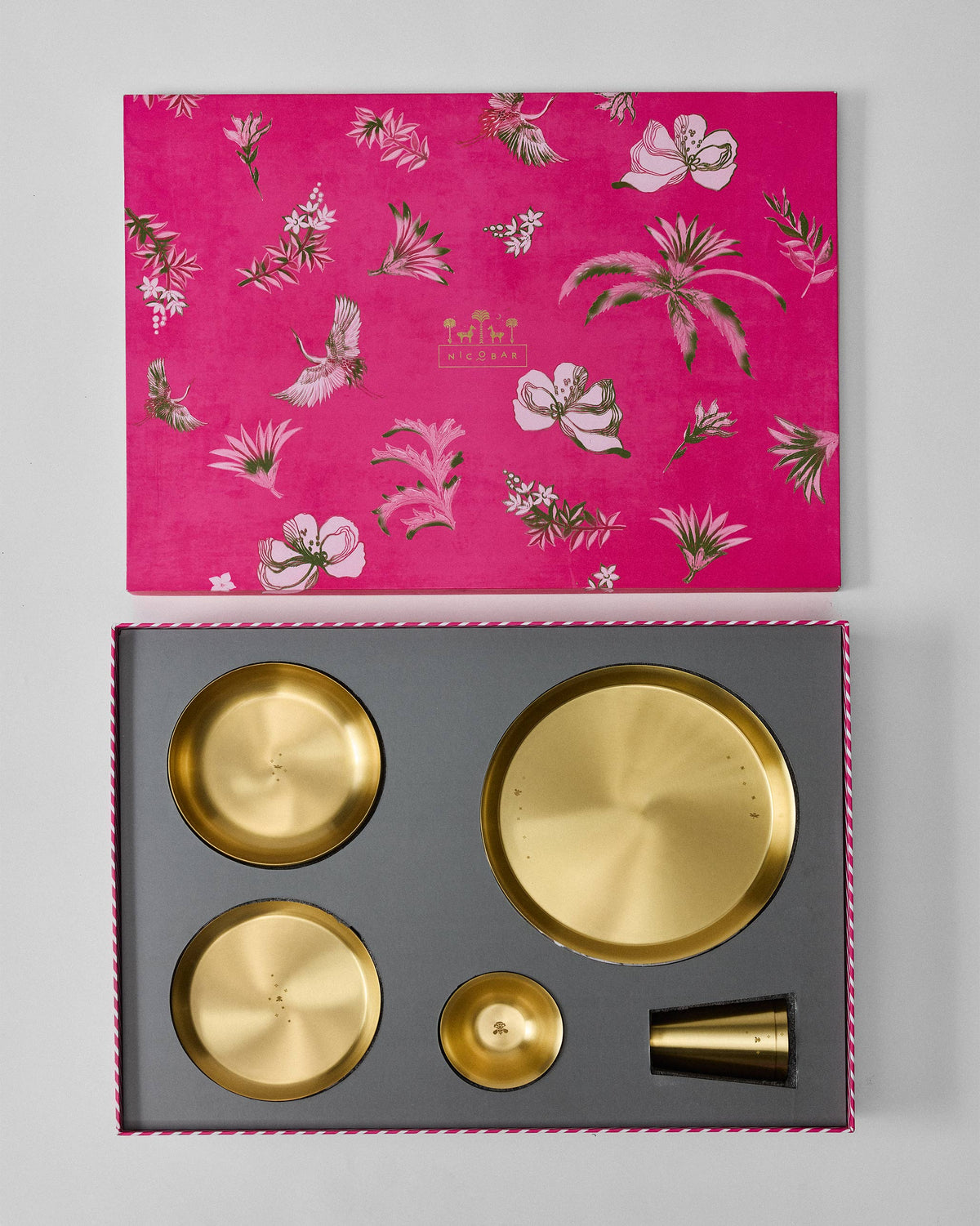 Madhu Dinner Gift Set packed in an open box, with the lid lifted above the gold pieces.