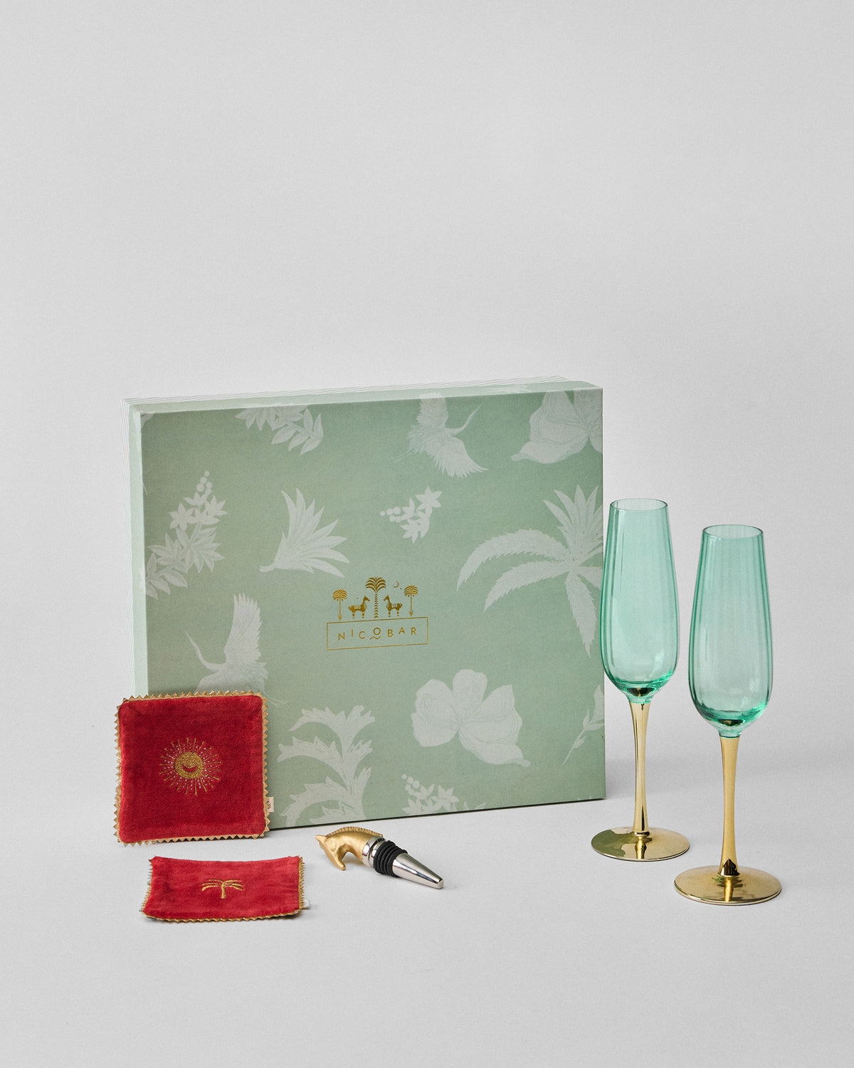 Prance gift set with green flutes, velvet coasters, and bottle stopper.