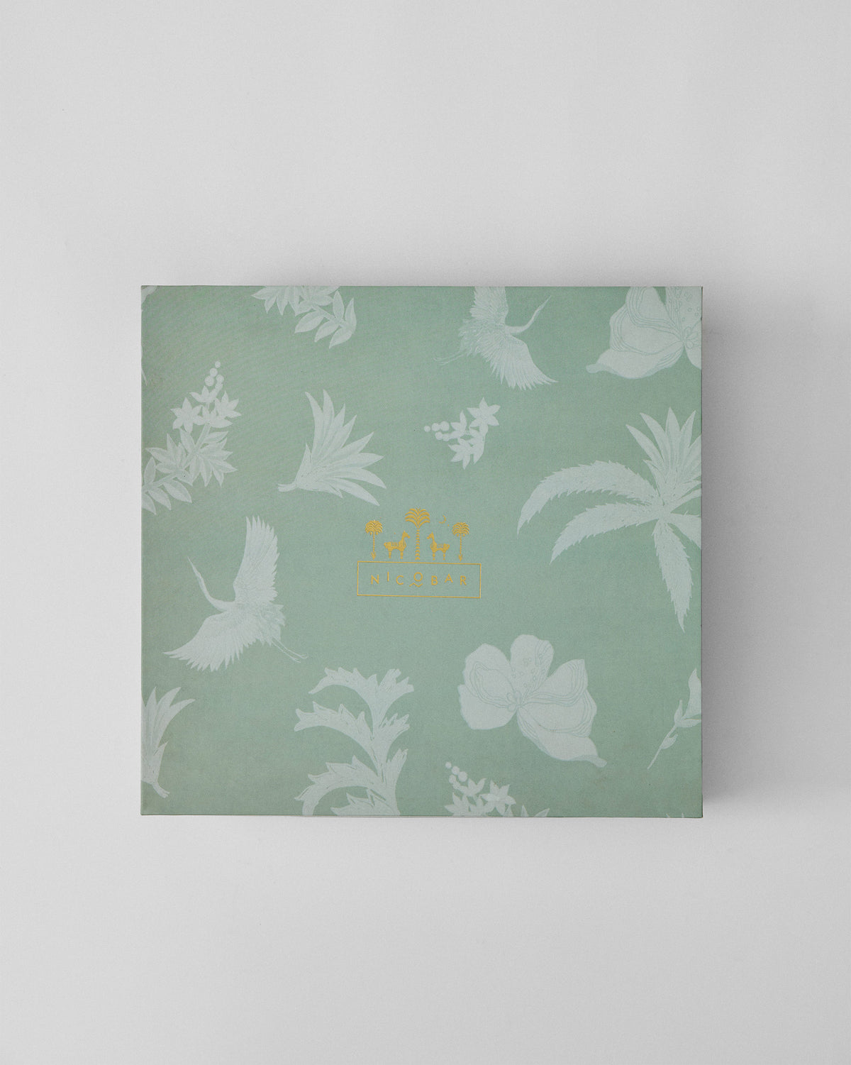 Closed sage Prance gift box with crane print and gold logo.