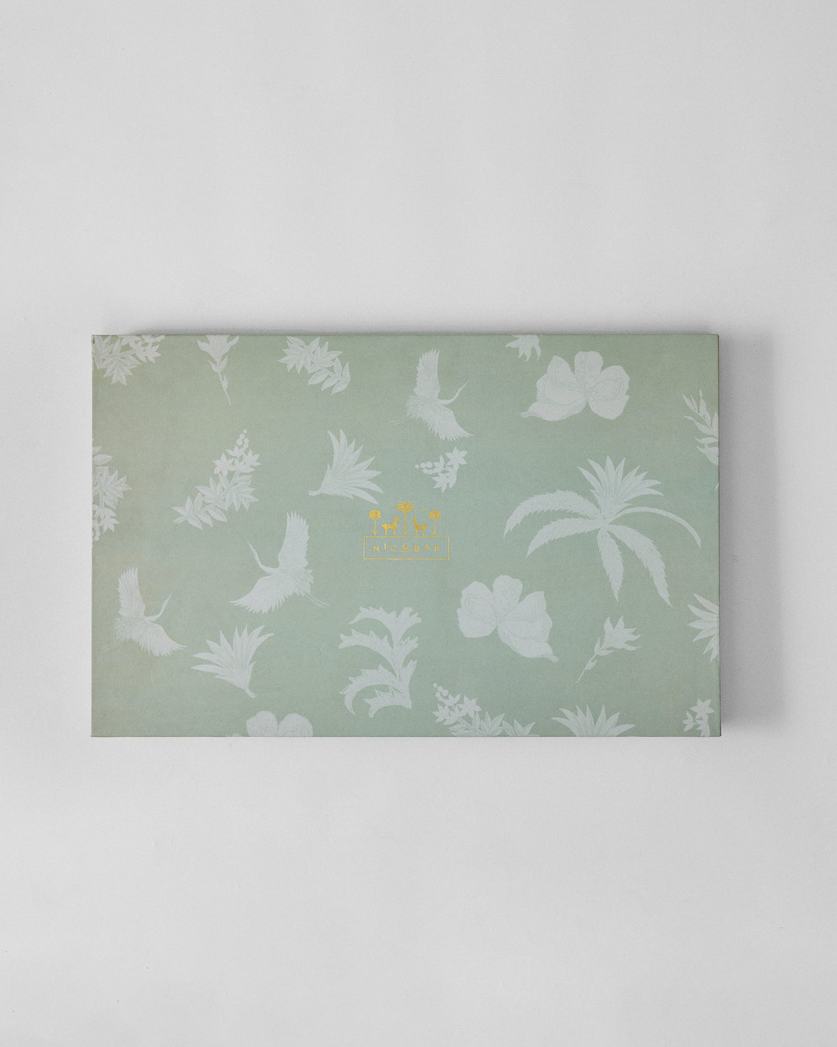 Sage green Reverie gift box with white crane and botanical print.