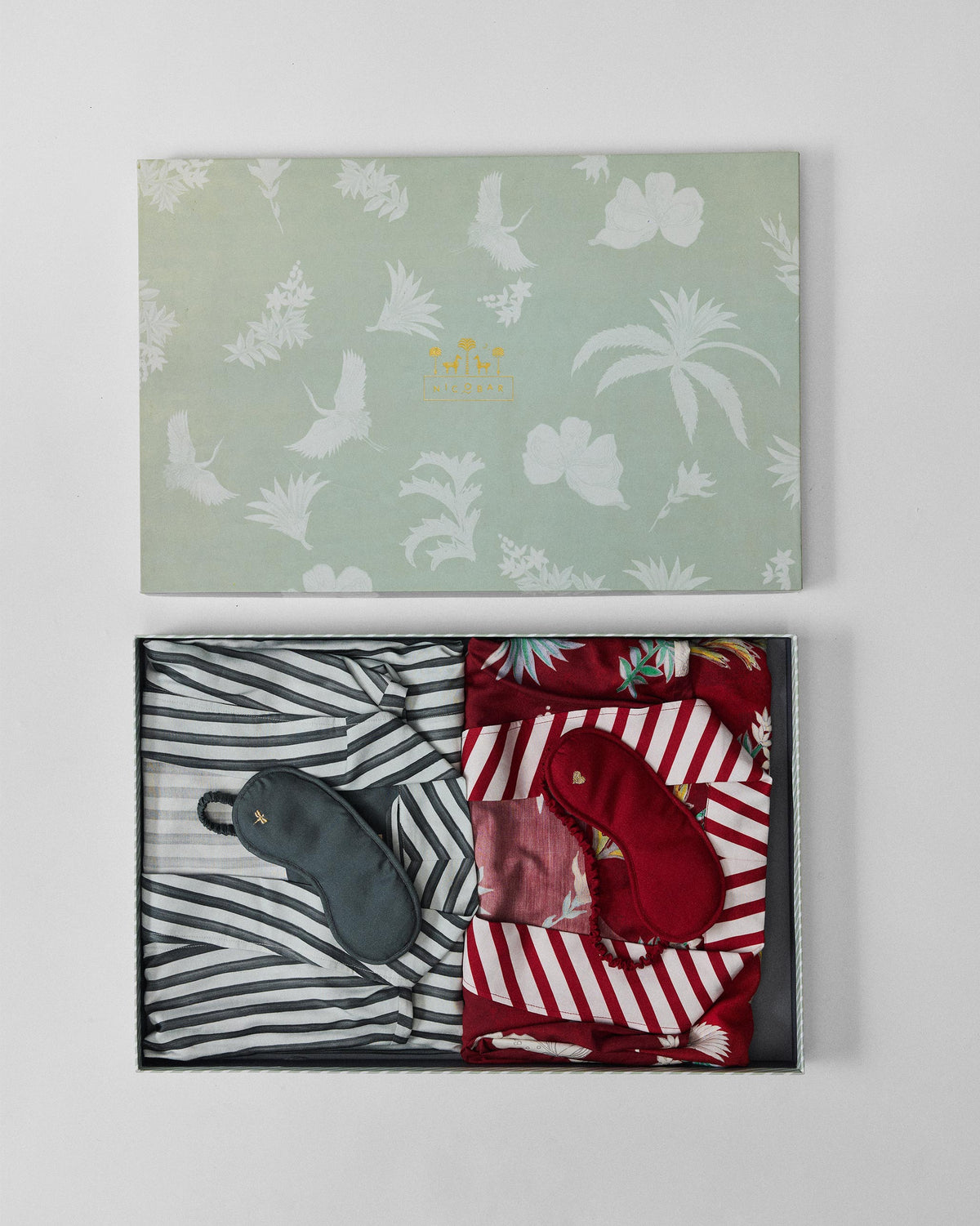 Open Reverie gift box with striped and red robes and matching sleep masks.
