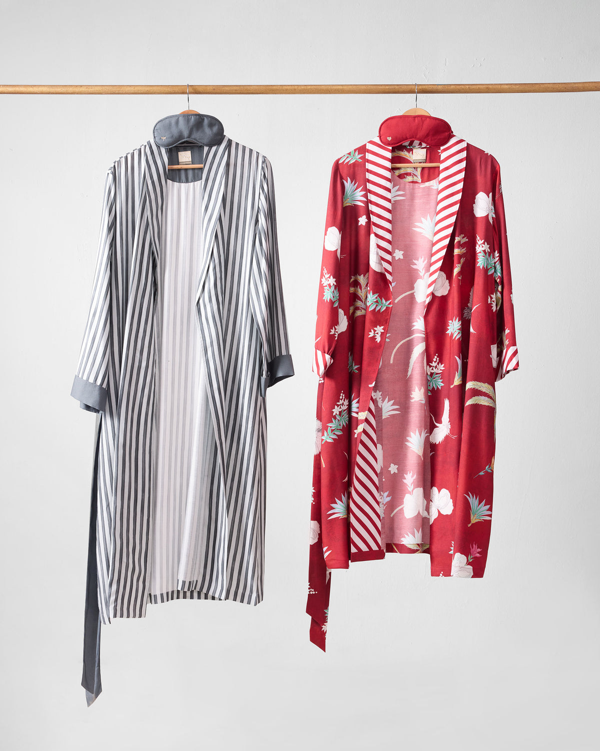 Open Reverie robes showing striped and red botanical fronts with sleep masks.