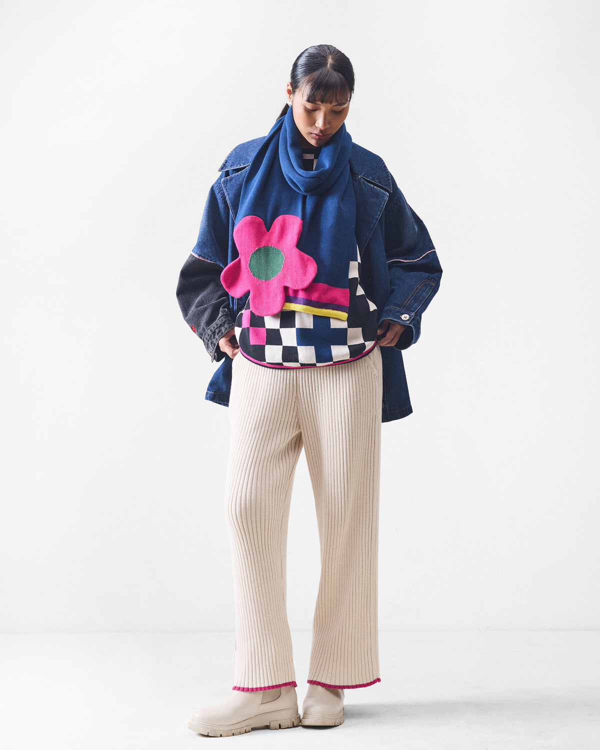 Person wearing ivory rib knit trousers with pink tip hems.