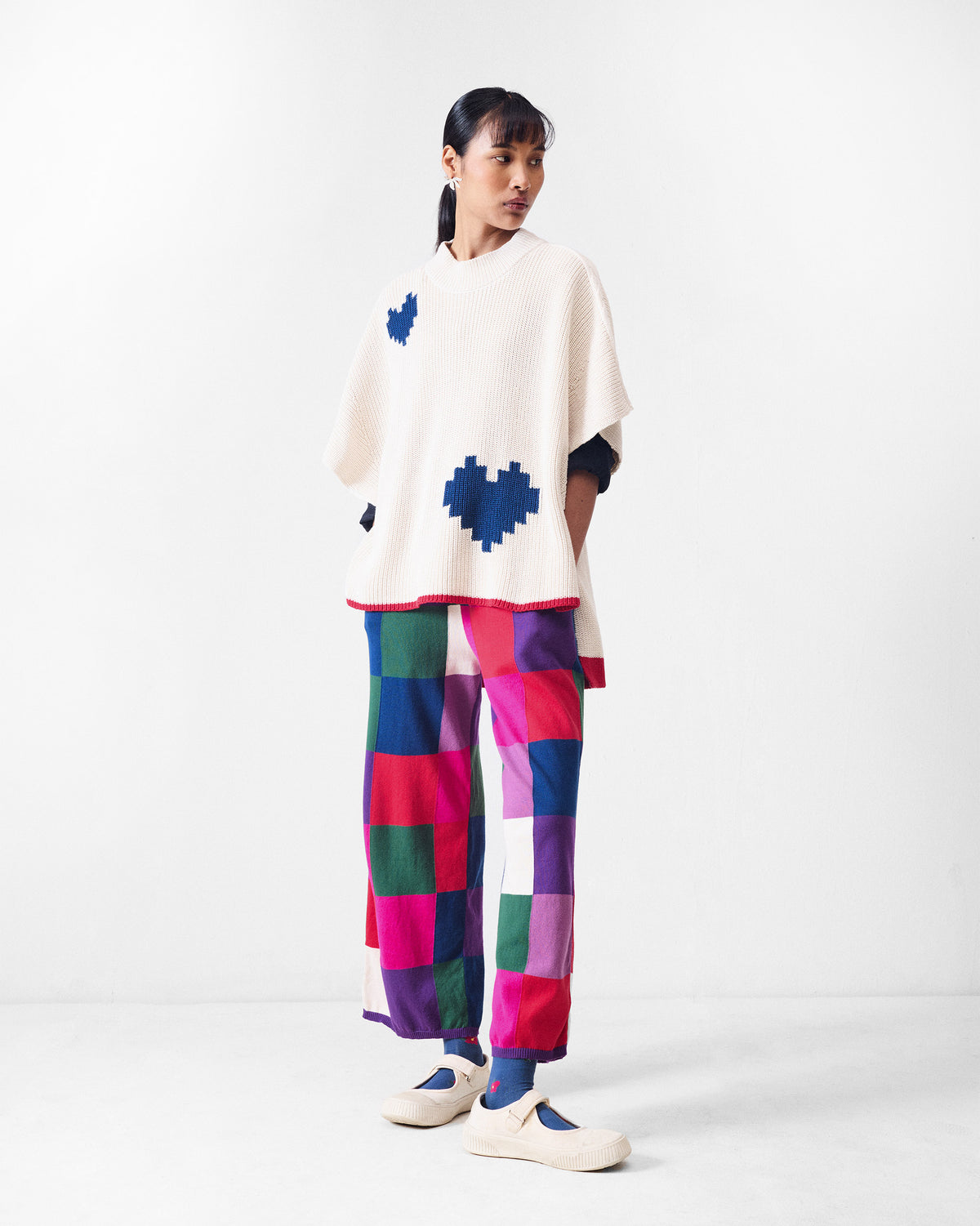 Person wearing multicolour check knit trousers with a wide-leg fit.