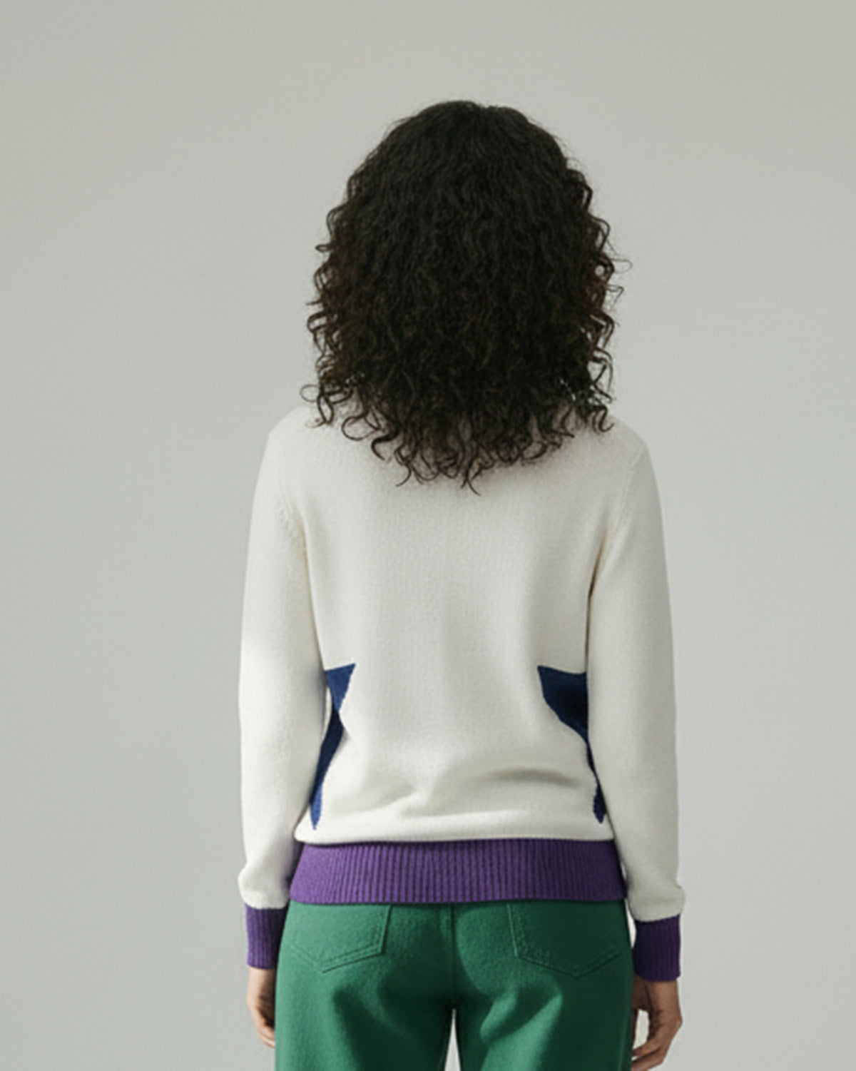 Back of an ivory Crew Neck Sweater with navy star details and a purple hem.