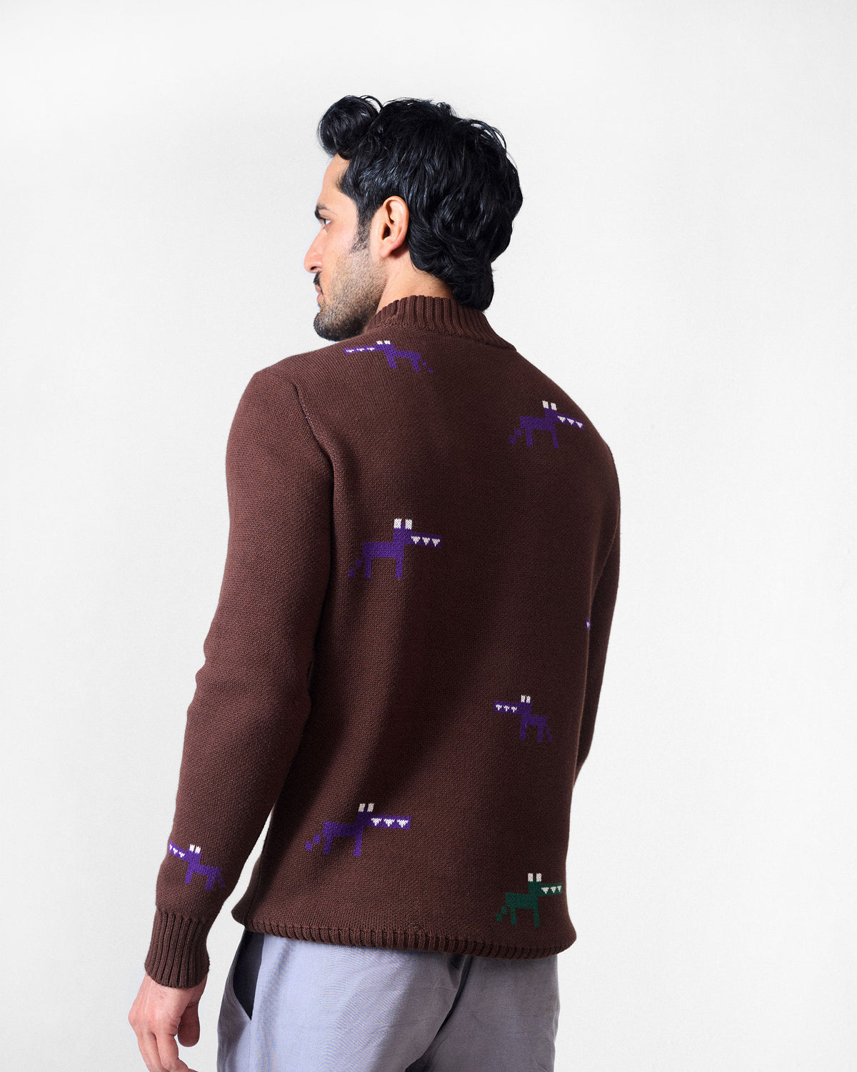 Back of a brown crew neck sweater with scattered pixel animal motifs.