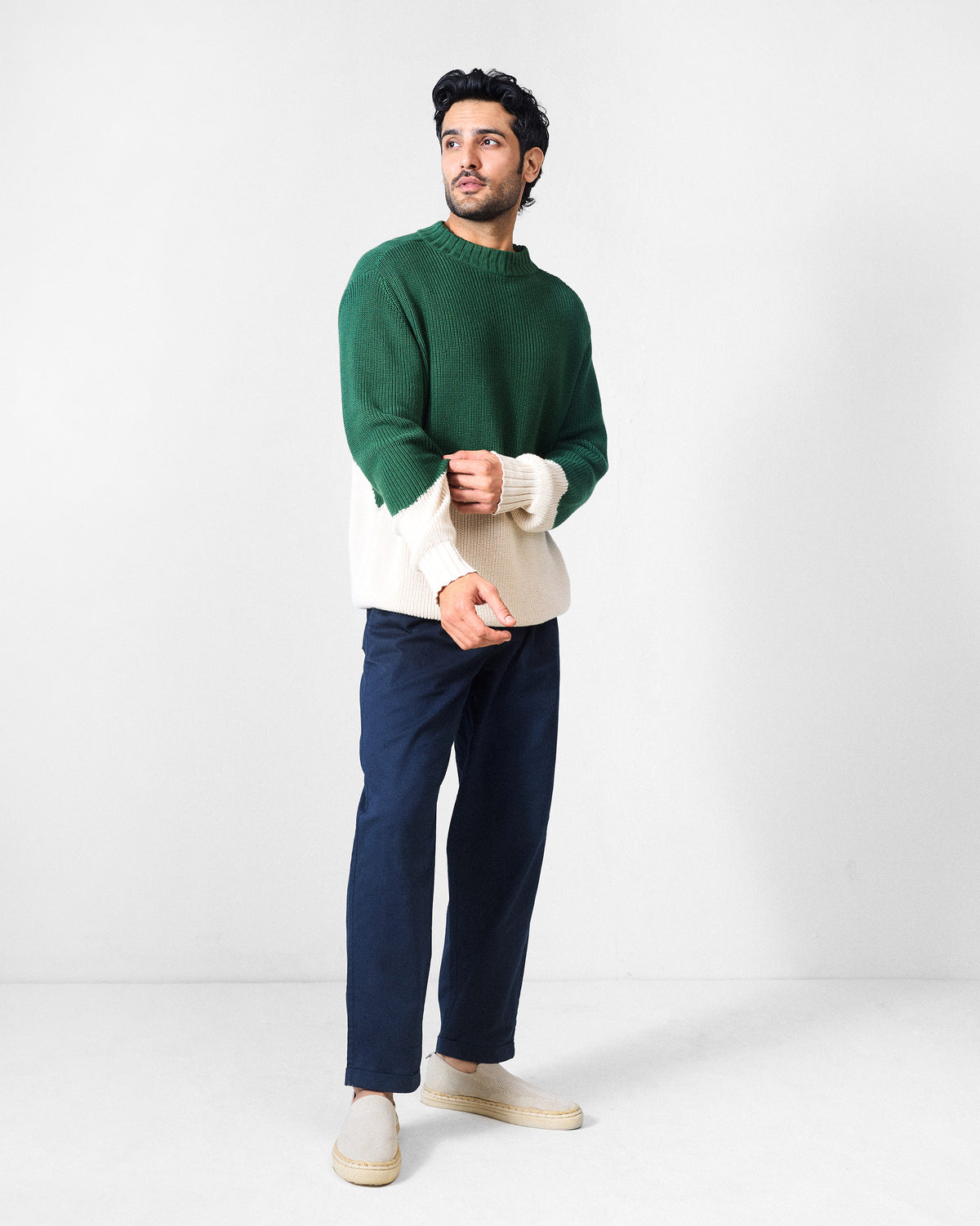 Full-length view of a green and ivory colour-block crew neck sweater.