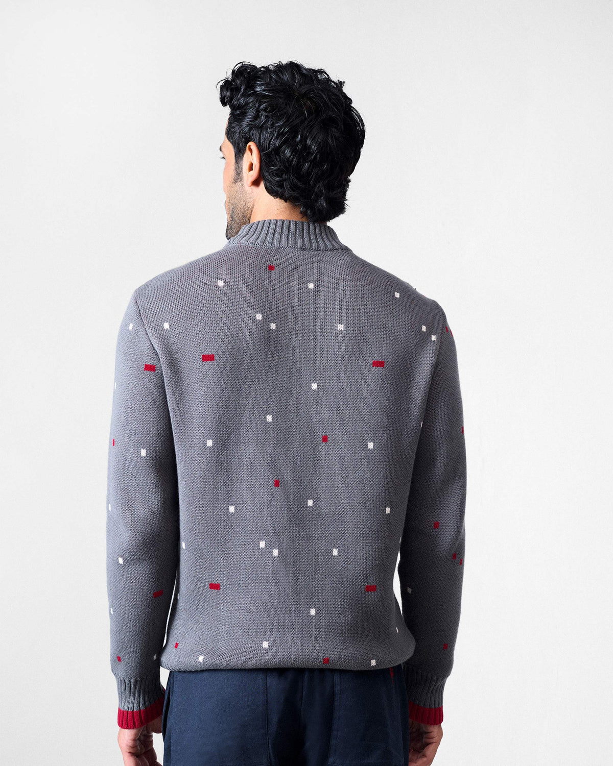 Back of a charcoal Crew Neck sweater with a red-and-white pixel pattern and red cuff tipping.