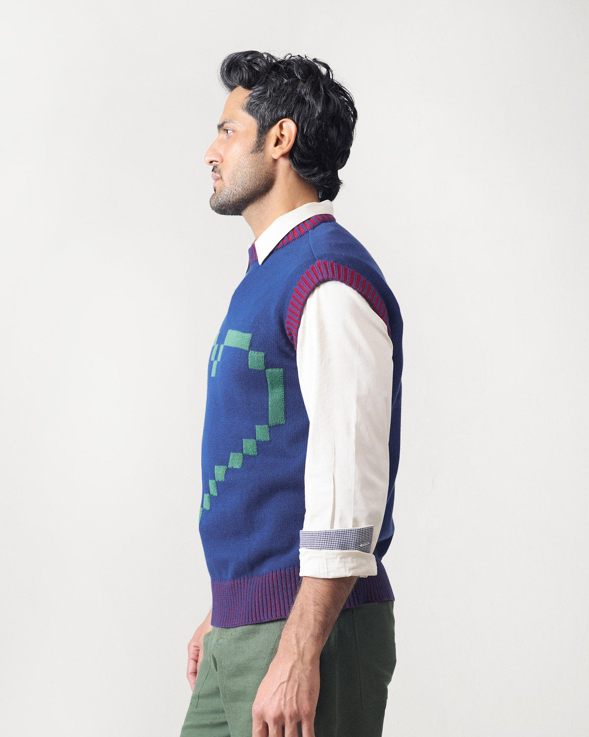 Side view of a navy sleeveless Pixel Sweater with striped ribbed armholes.
