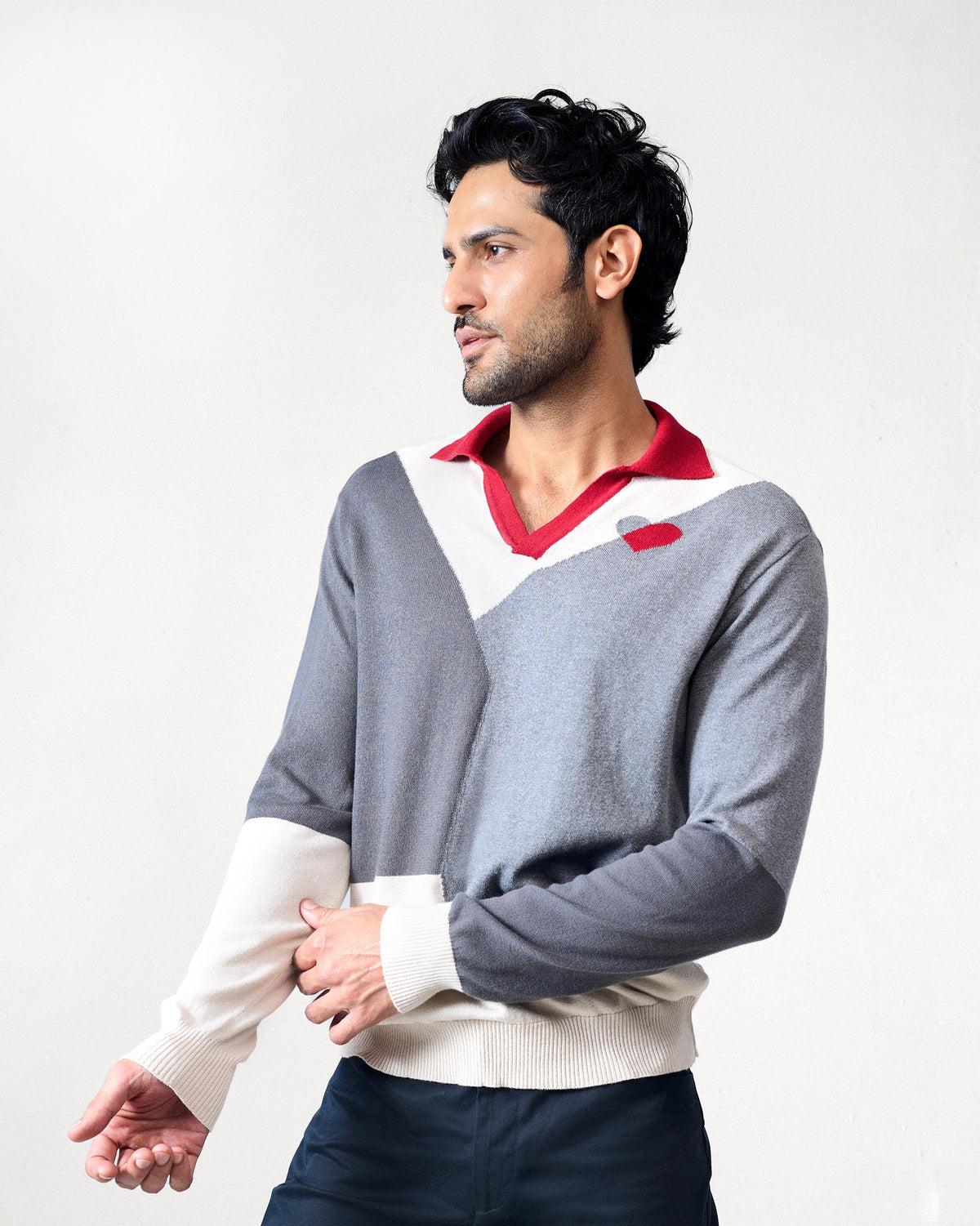 Side view of a grey Dom Sweater with colour blocks and a red collar.