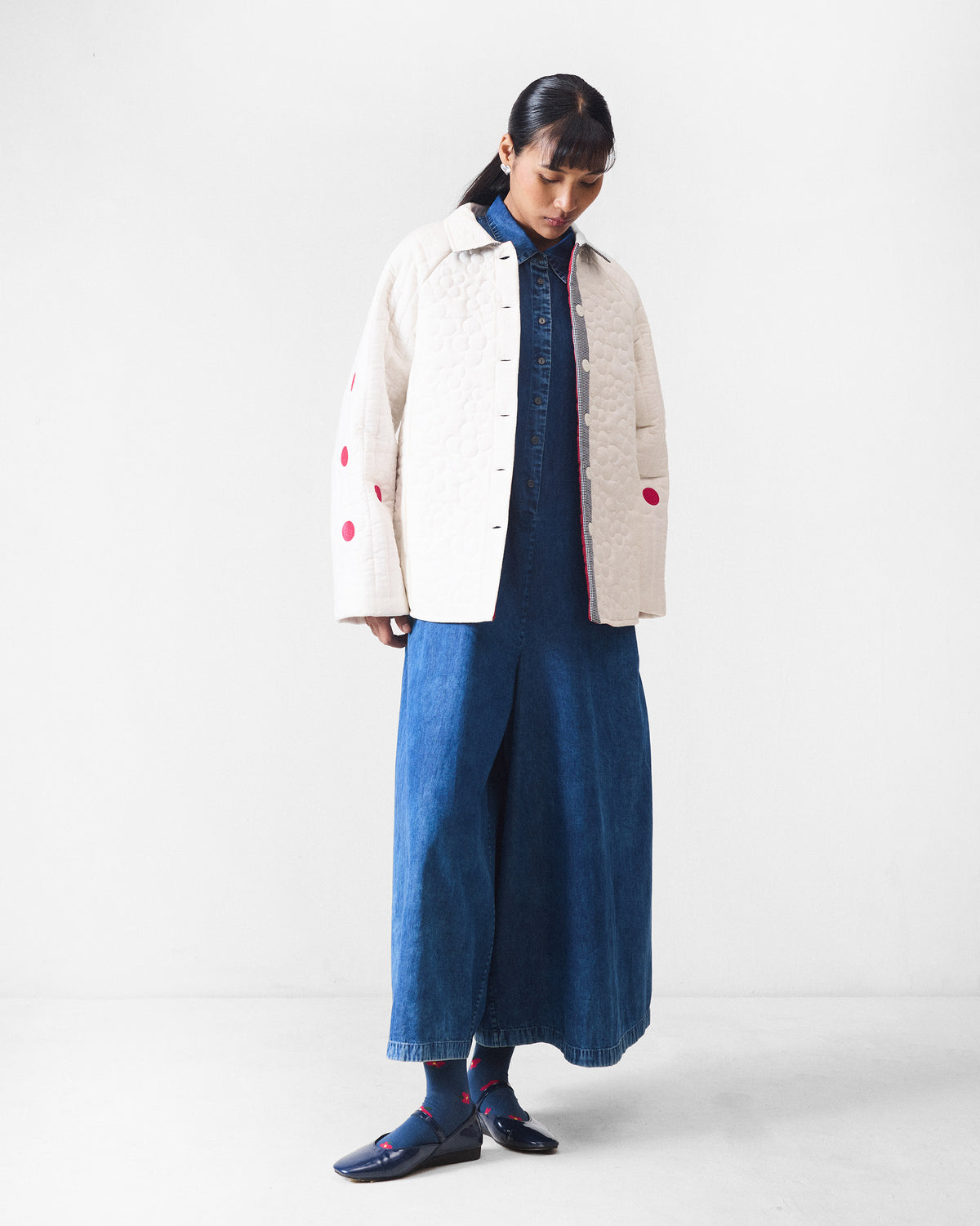 Full-length view of an ivory Botanik jacket with fuchsia sleeve accents over denim.