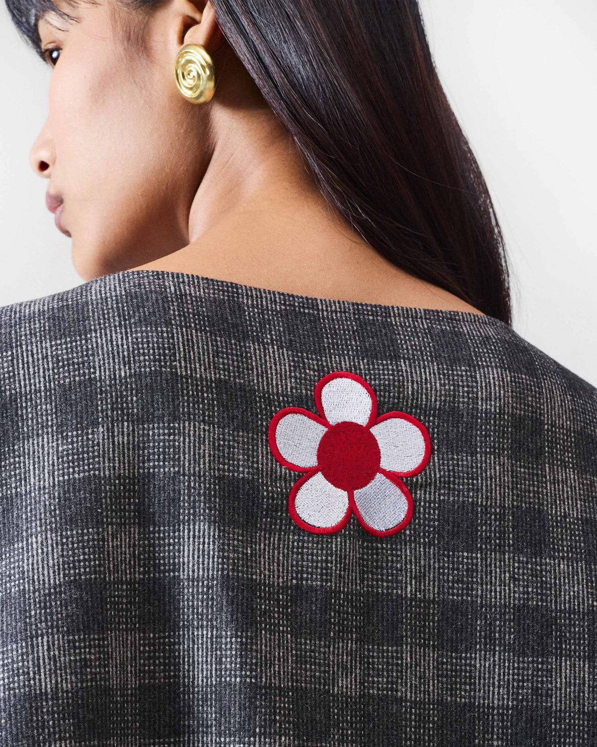 Close-up of Fable Top back with a red and white embroidered flower.