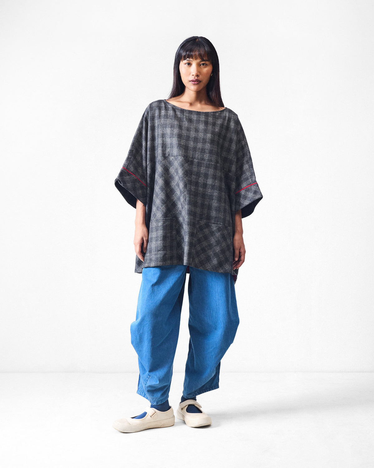 Fable Top worn full length in black and charcoal check with wide sleeves.