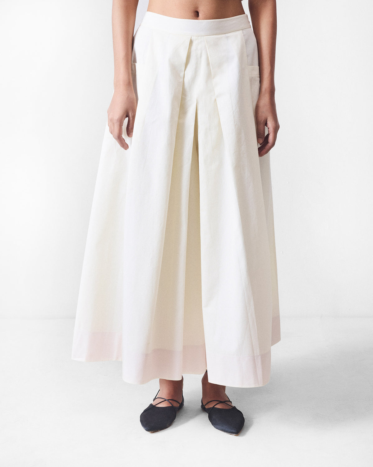 Ivory Twirl skort with deep front pleats and a pale hem band.