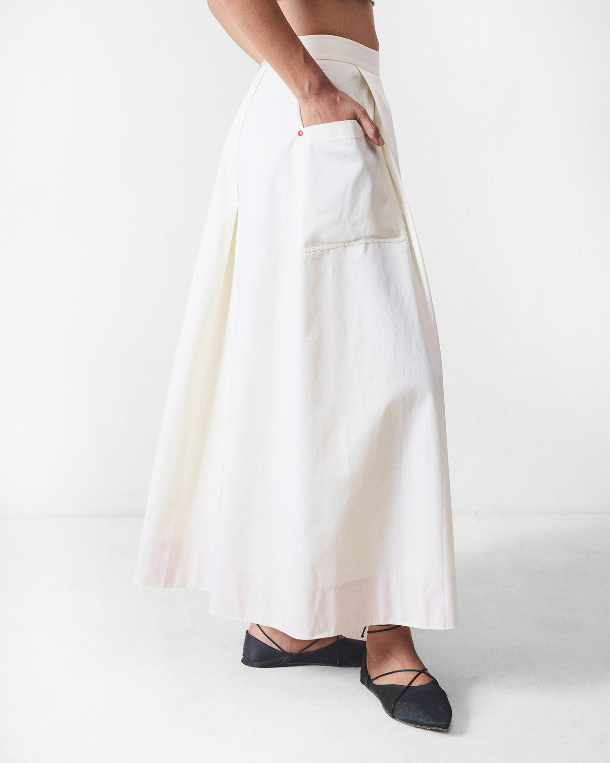 Side view of an ivory Twirl skort showing a large patch pocket.