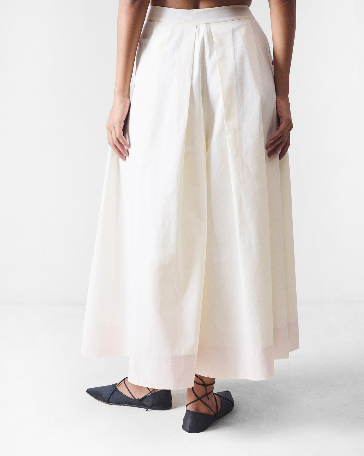 Back of an ivory Twirl skort with box pleats from the waistband.