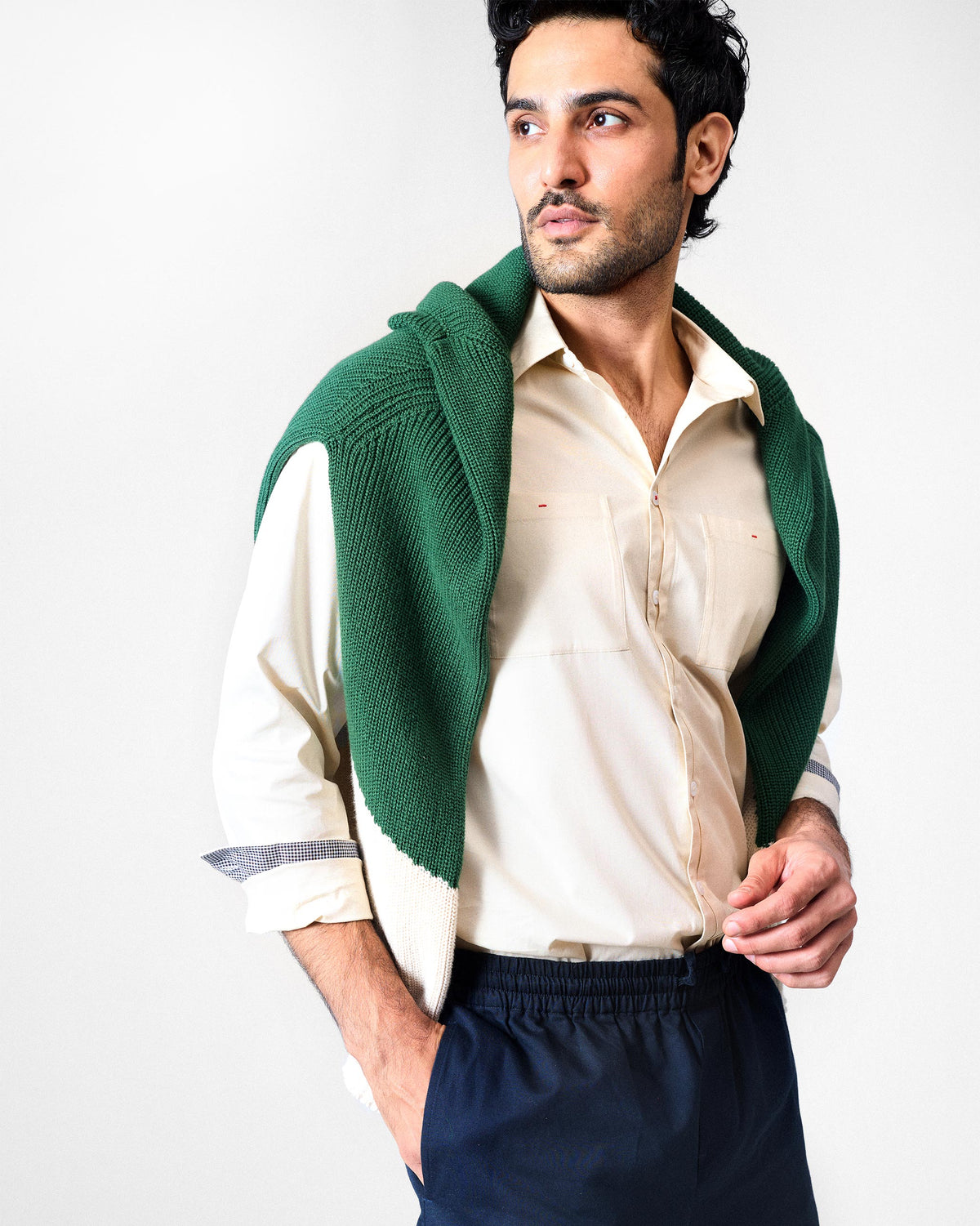 Ivory Abe shirt styled with a green sweater draped on the shoulders.