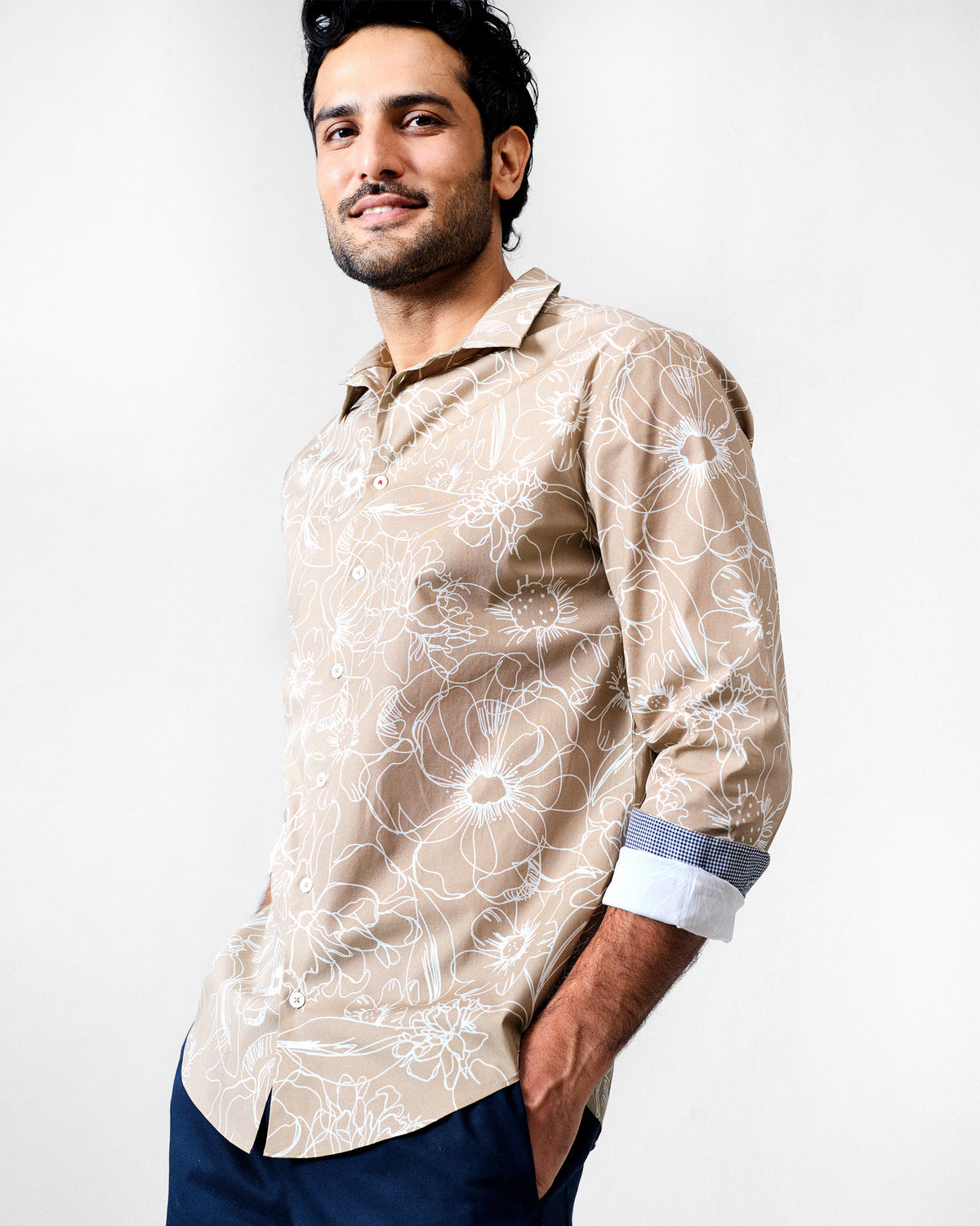 Person wearing a light brown Hakuna Shirt with a floral print.
