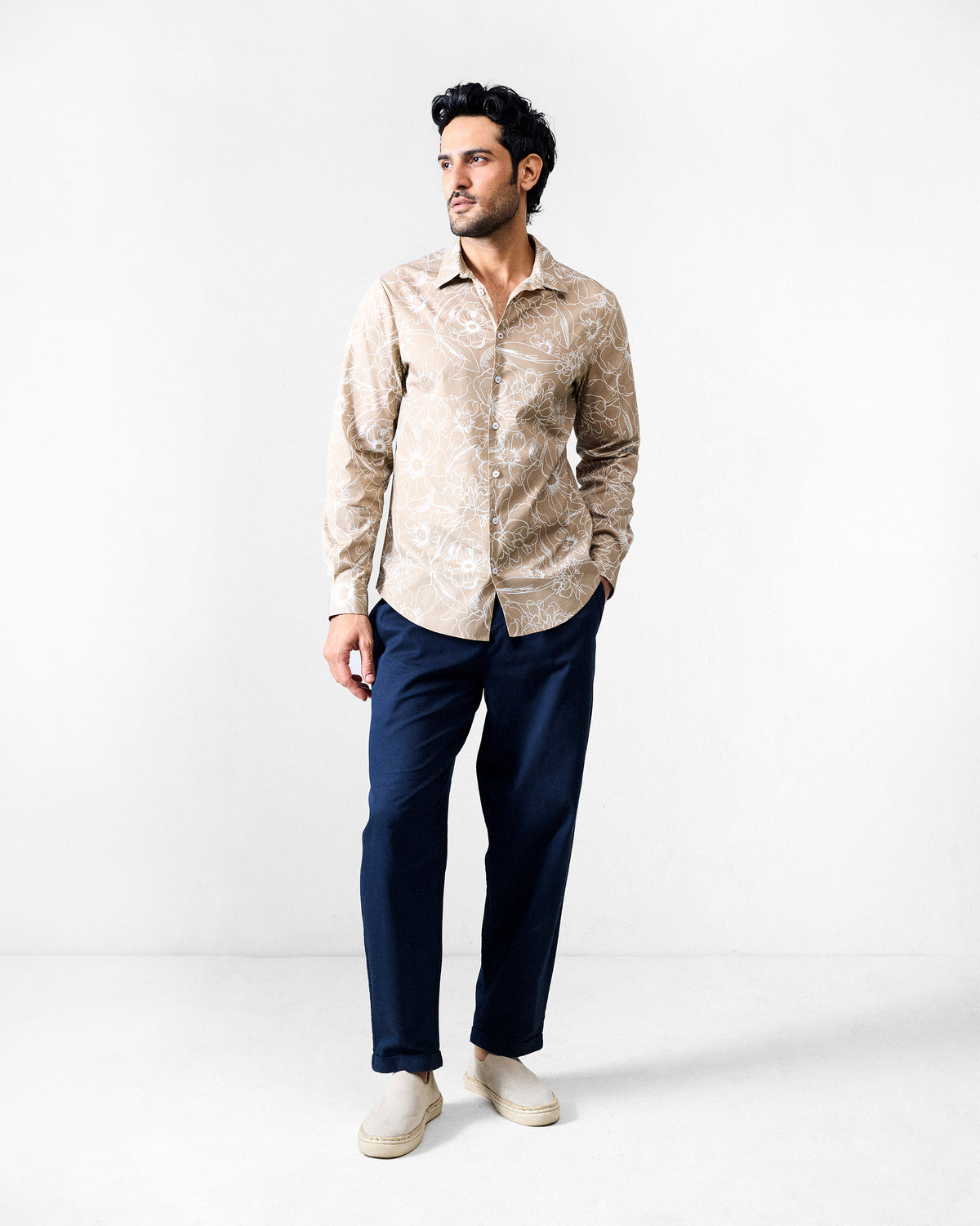Person wearing a light brown Hakuna Shirt with a floral print.