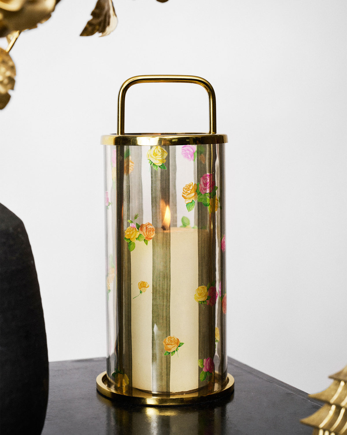 Striped Roses lantern with a pillar candle burning inside.