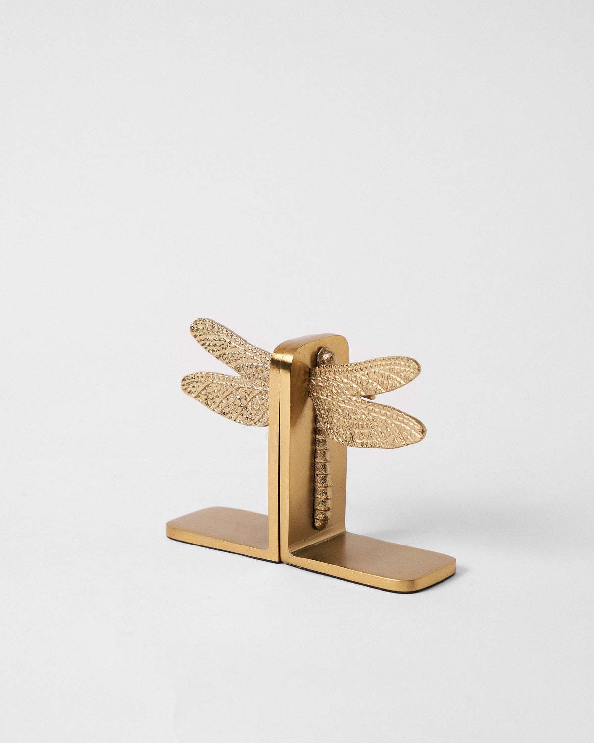 Gold dragonfly bookends placed back-to-back showing L-shaped bases and wings.