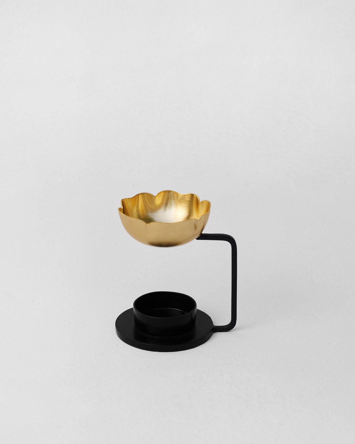 Bloom diffuser with a brass petal-edged bowl on a black stand.