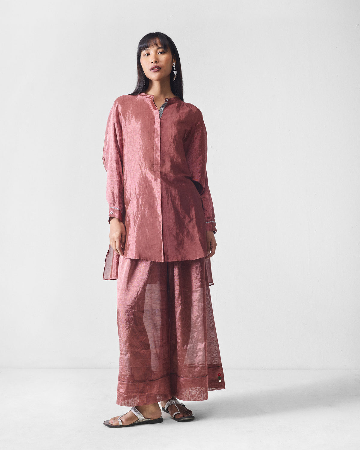 Person wearing metallic pink Charisma pants with a matching long tunic.