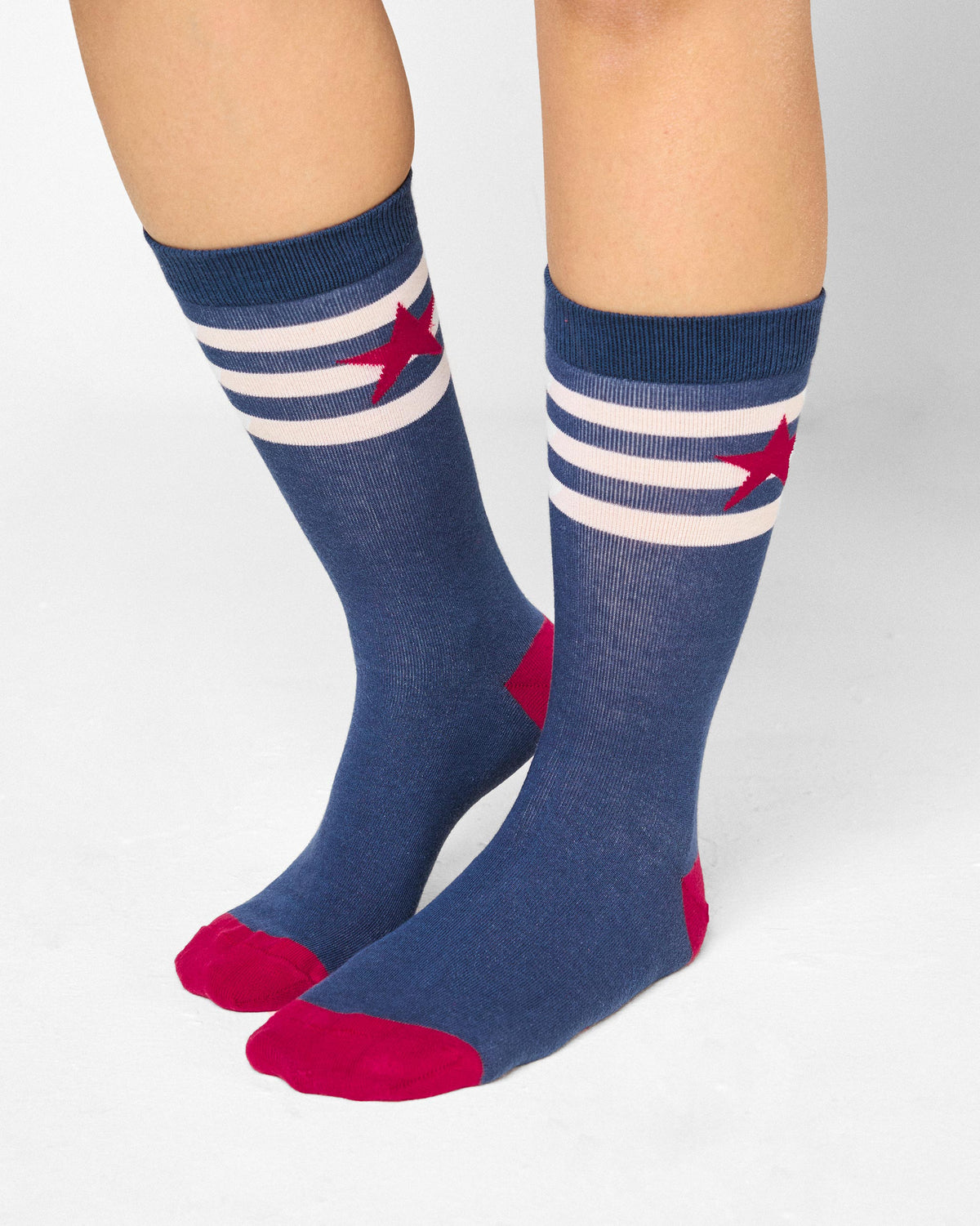 Person wearing navy Starbed Socks with a red star and red toe and heel.