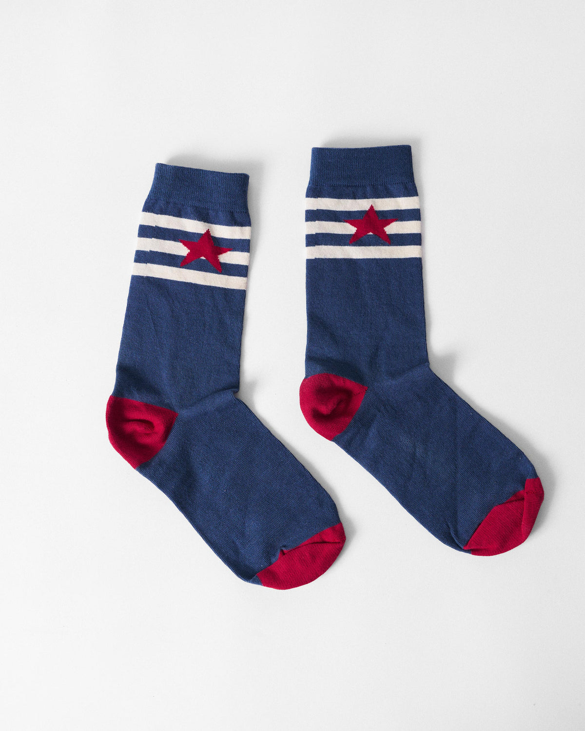 Pair of navy Starbed Socks with a red star on white stripes and red heels.