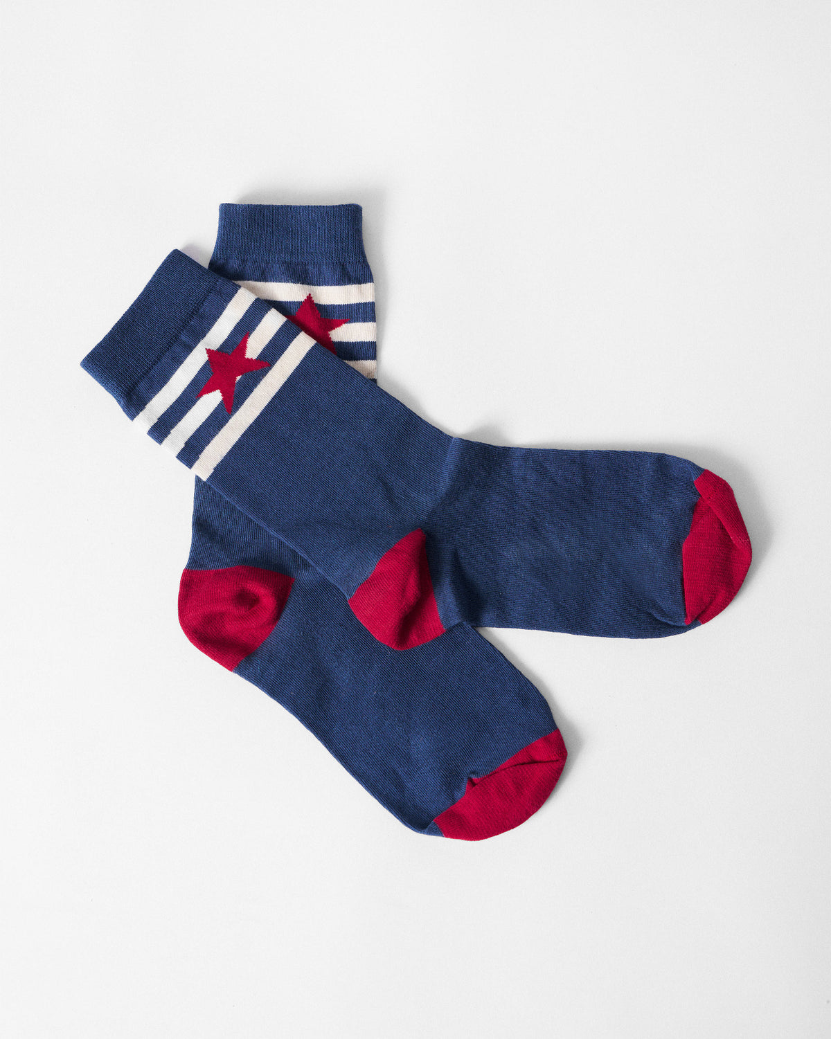 Navy Starbed Socks crossed flat with a red star and contrasting red heels.