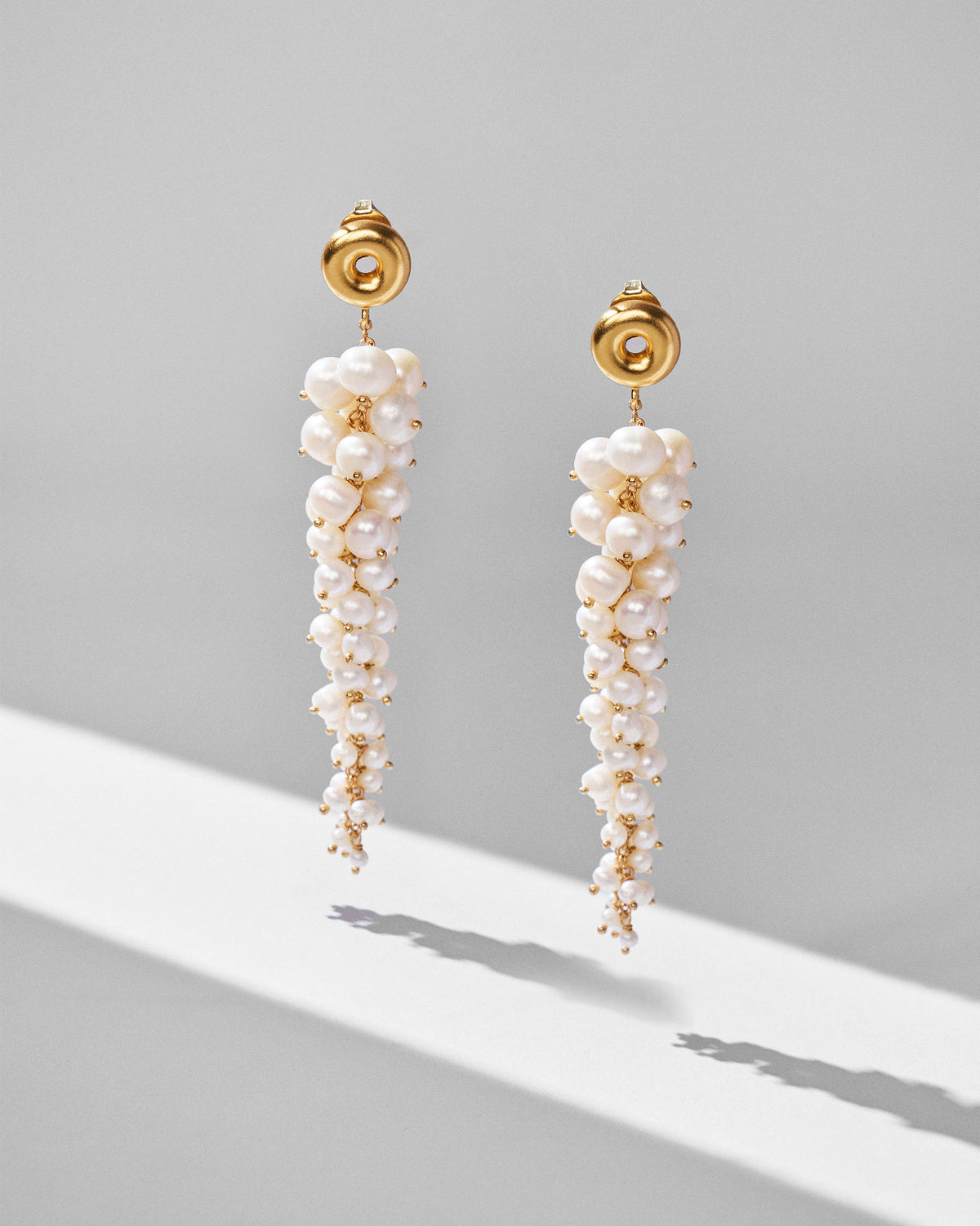 Gold Mogra shoulder dusters hanging to show dense tapering pearl clusters.