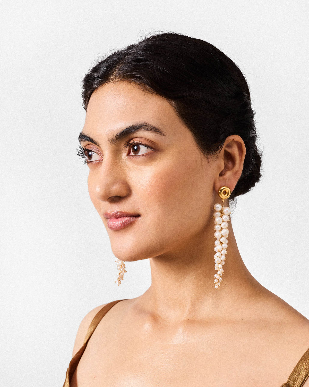 Person wearing gold Mogra shoulder dusters with cascading pearl clusters.