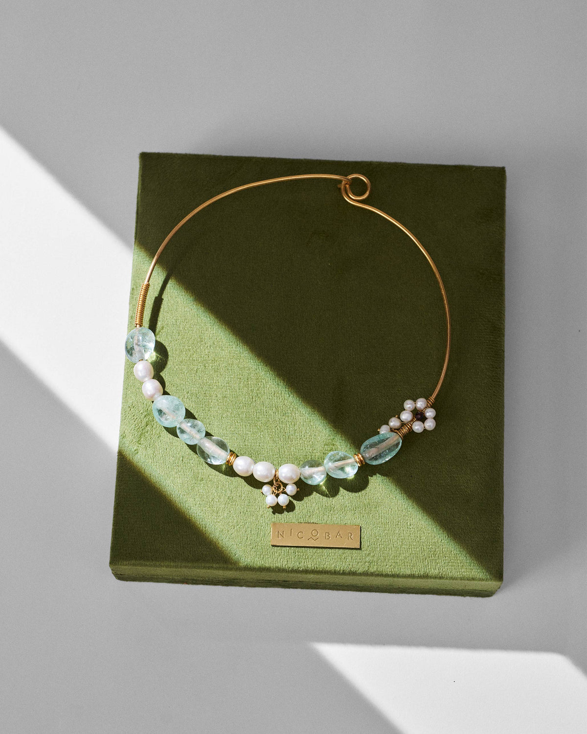 Noorani gold wire choker on a green Nicobar jewellery box.