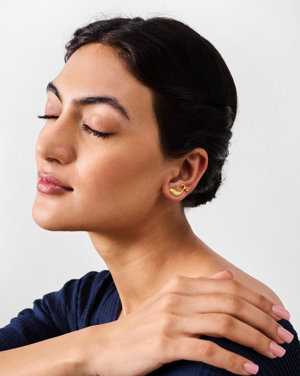 Side profile of a gold fish Jalpari stud on a person.