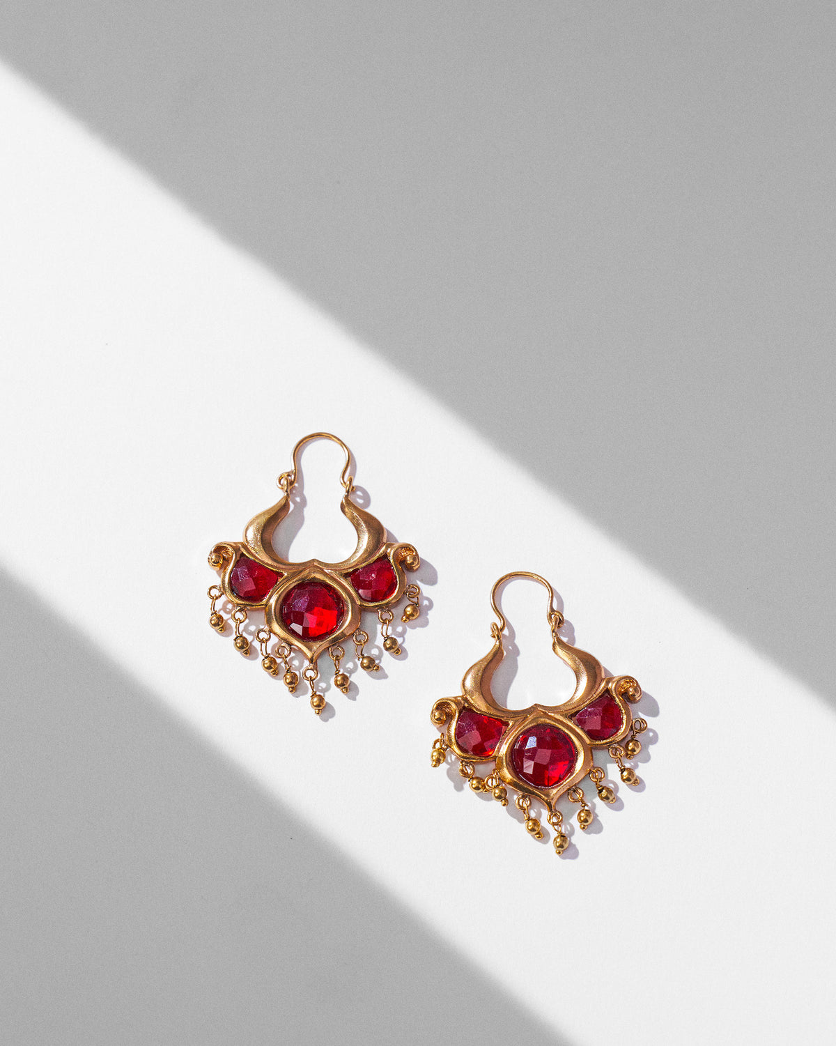 Pair of antique gold Darbaar Balis laid flat showing red glass and bead drops.