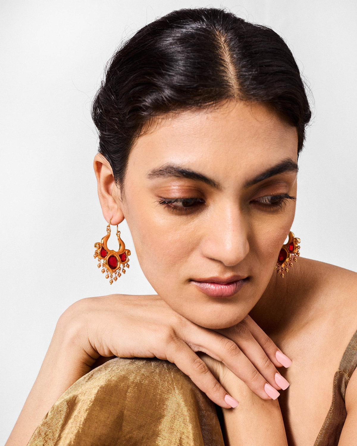 Person wearing antique gold Darbaar Balis with red glass stones and bead fringe.