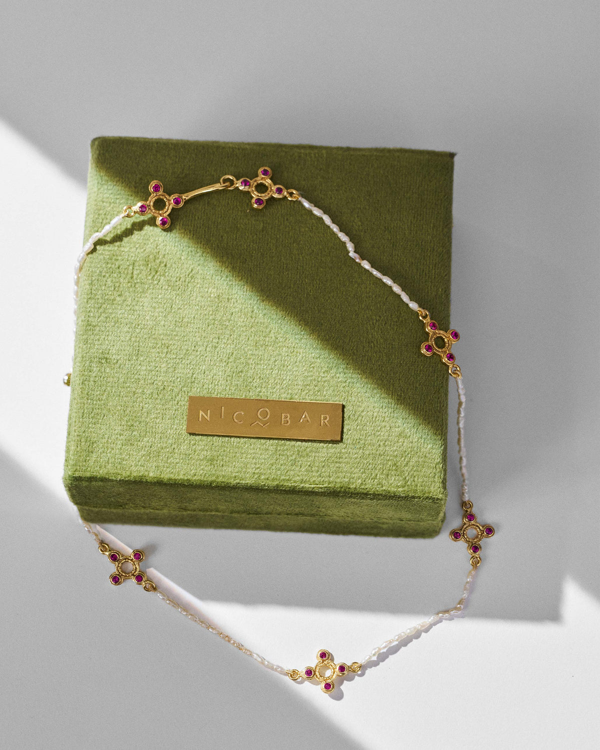 Gold Bindu pearl choker on an olive Nicobar velvet gift box.
