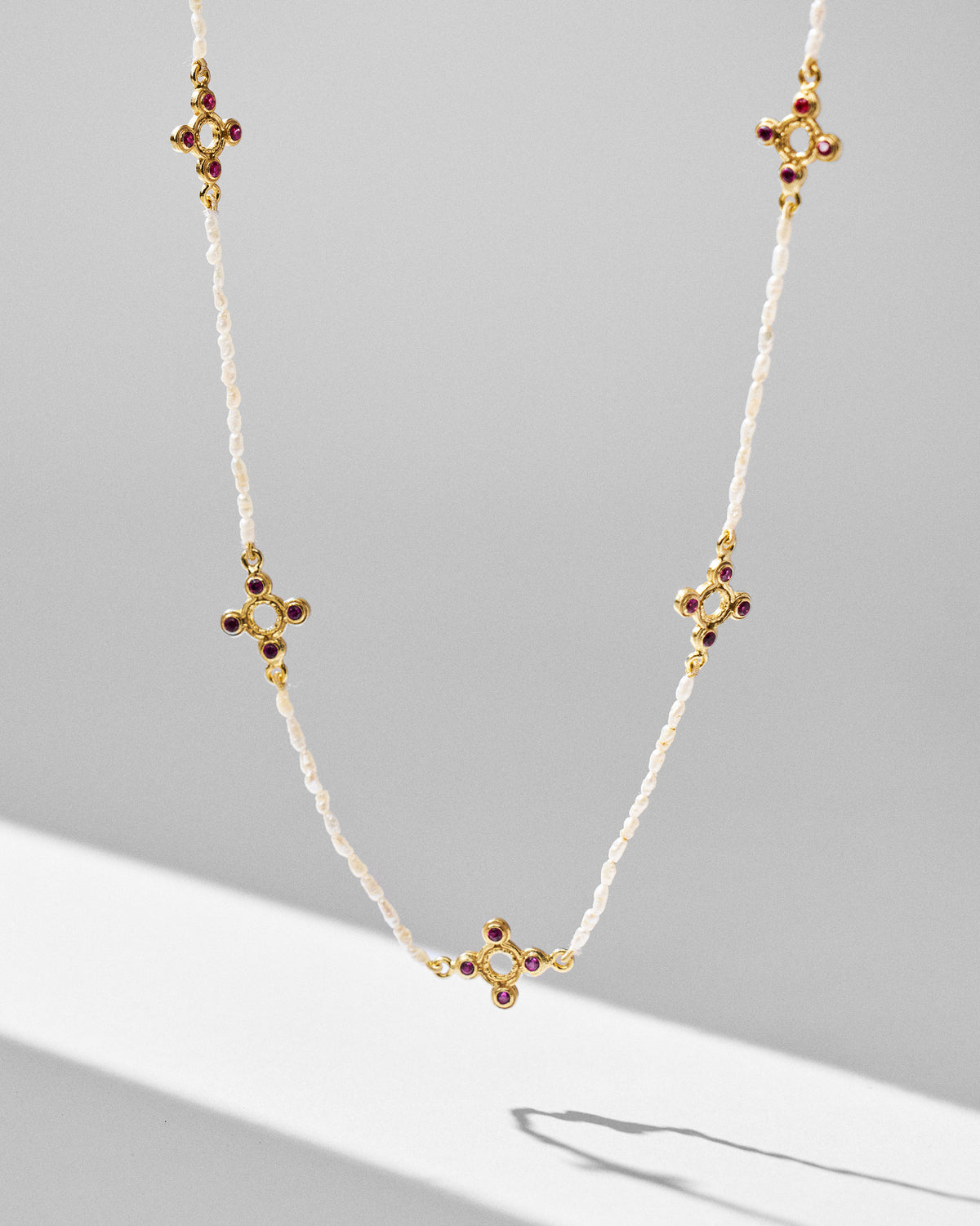 Gold Bindu pearl choker with five red stone motifs hanging in a U.