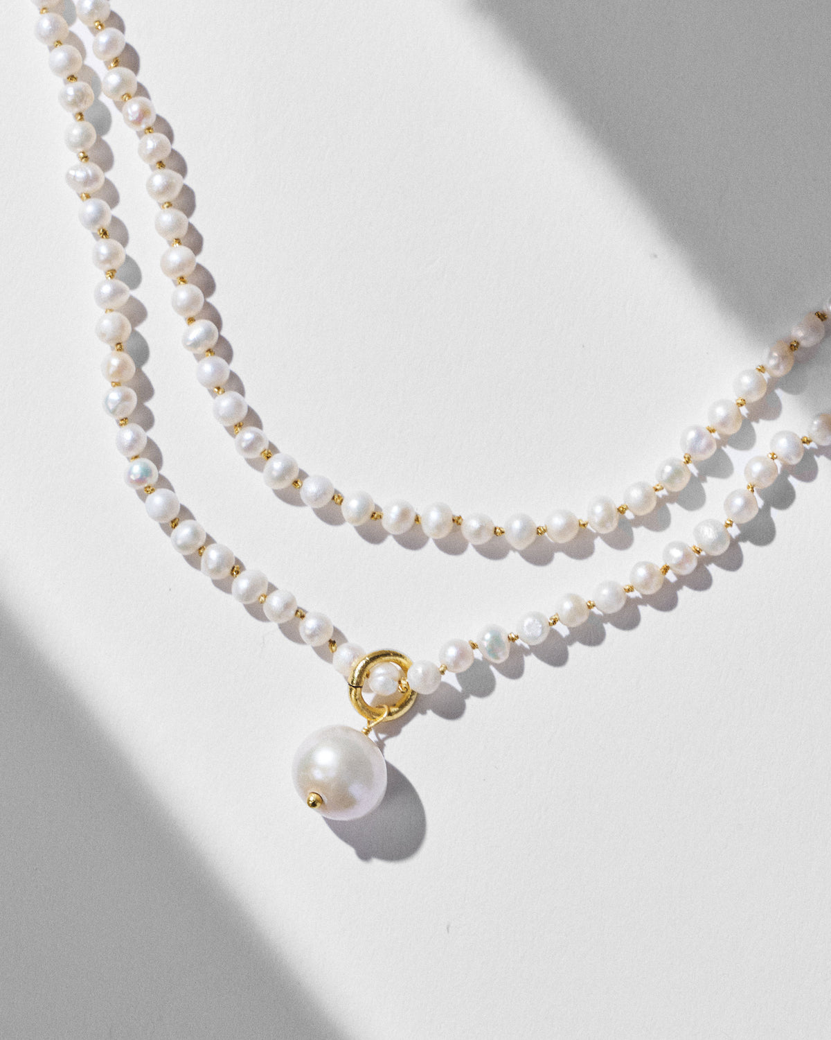 Close-up of Chandni pearl strands with a gold-ring pearl drop.
