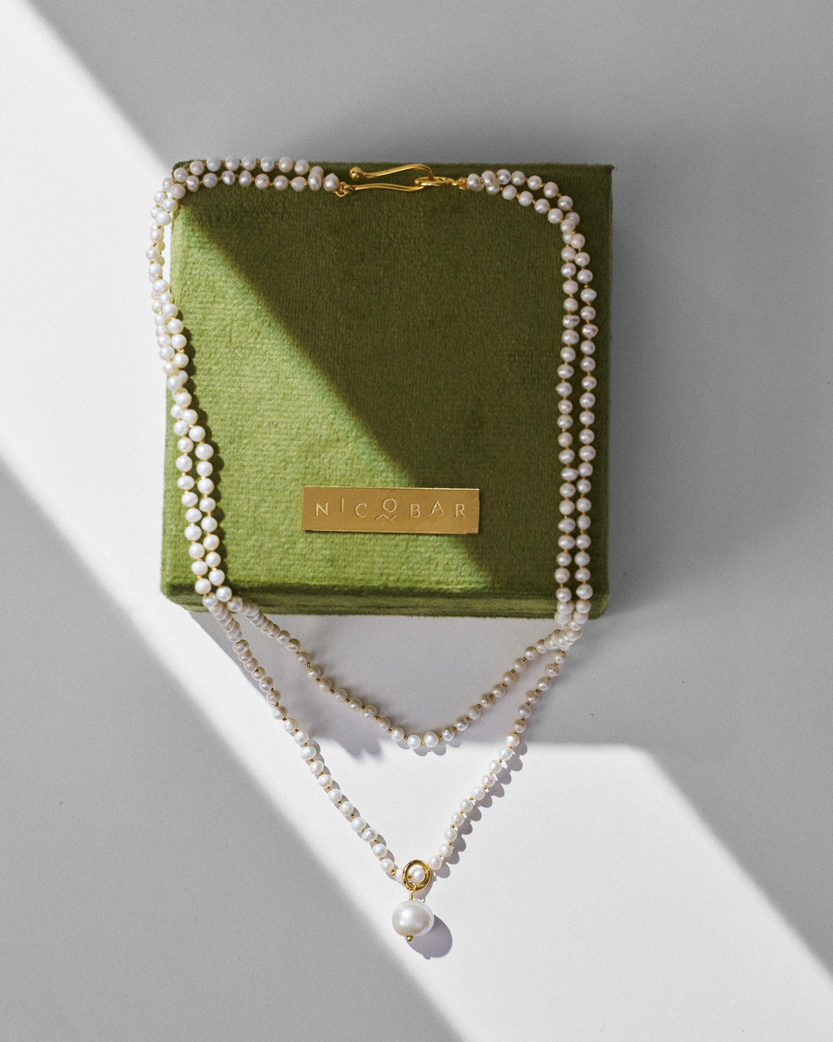 Chandni pearl necklace draped over a green Nicobar jewellery box.