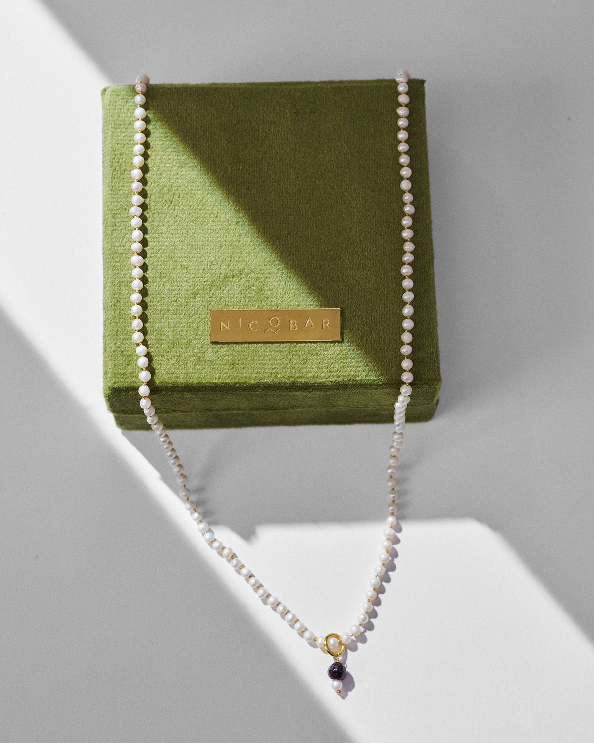 Chandni large pearl necklace draped around a green Nicobar jewelry box.