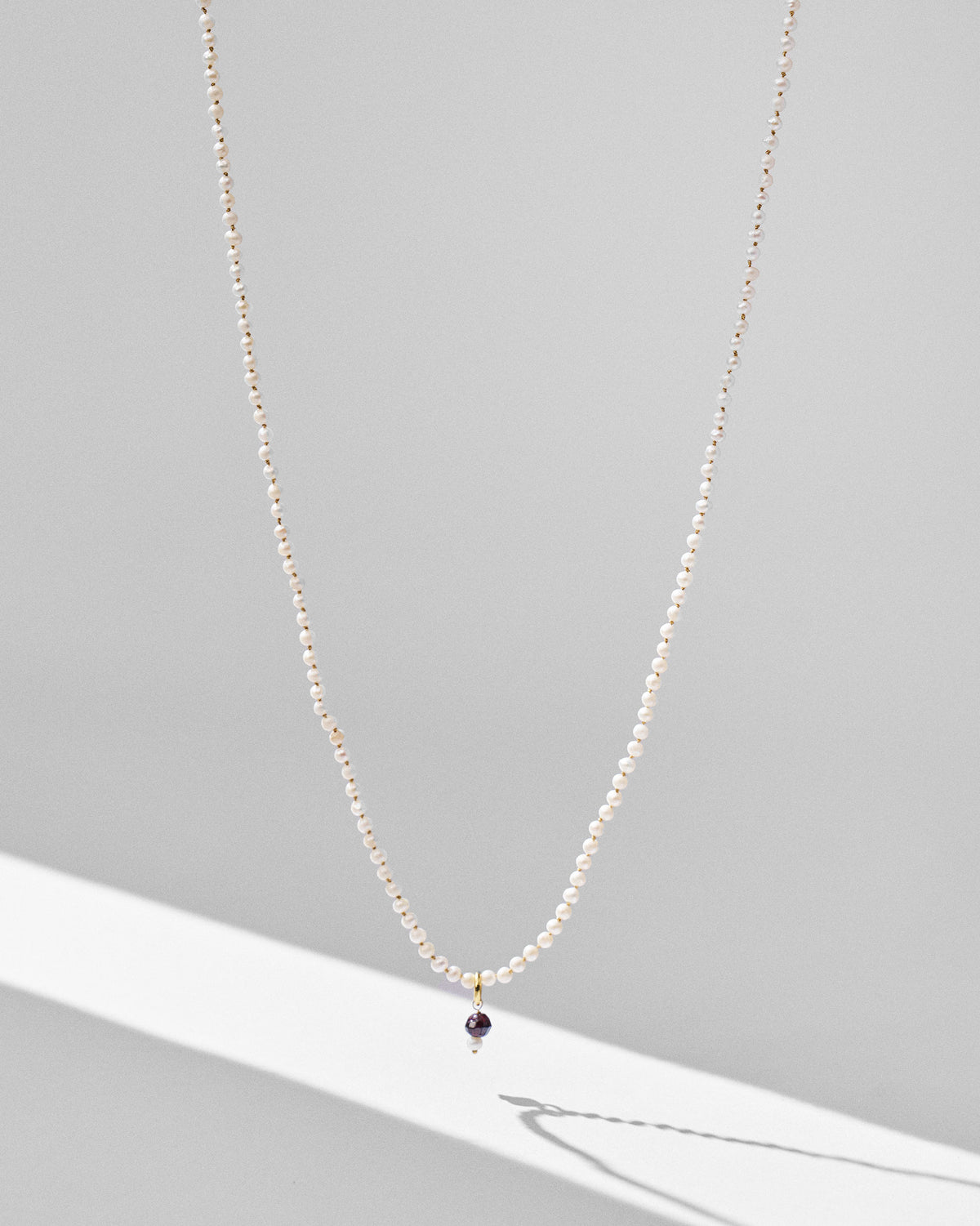 Chandni large pearl necklace with a purple bead and pearl drop pendant.